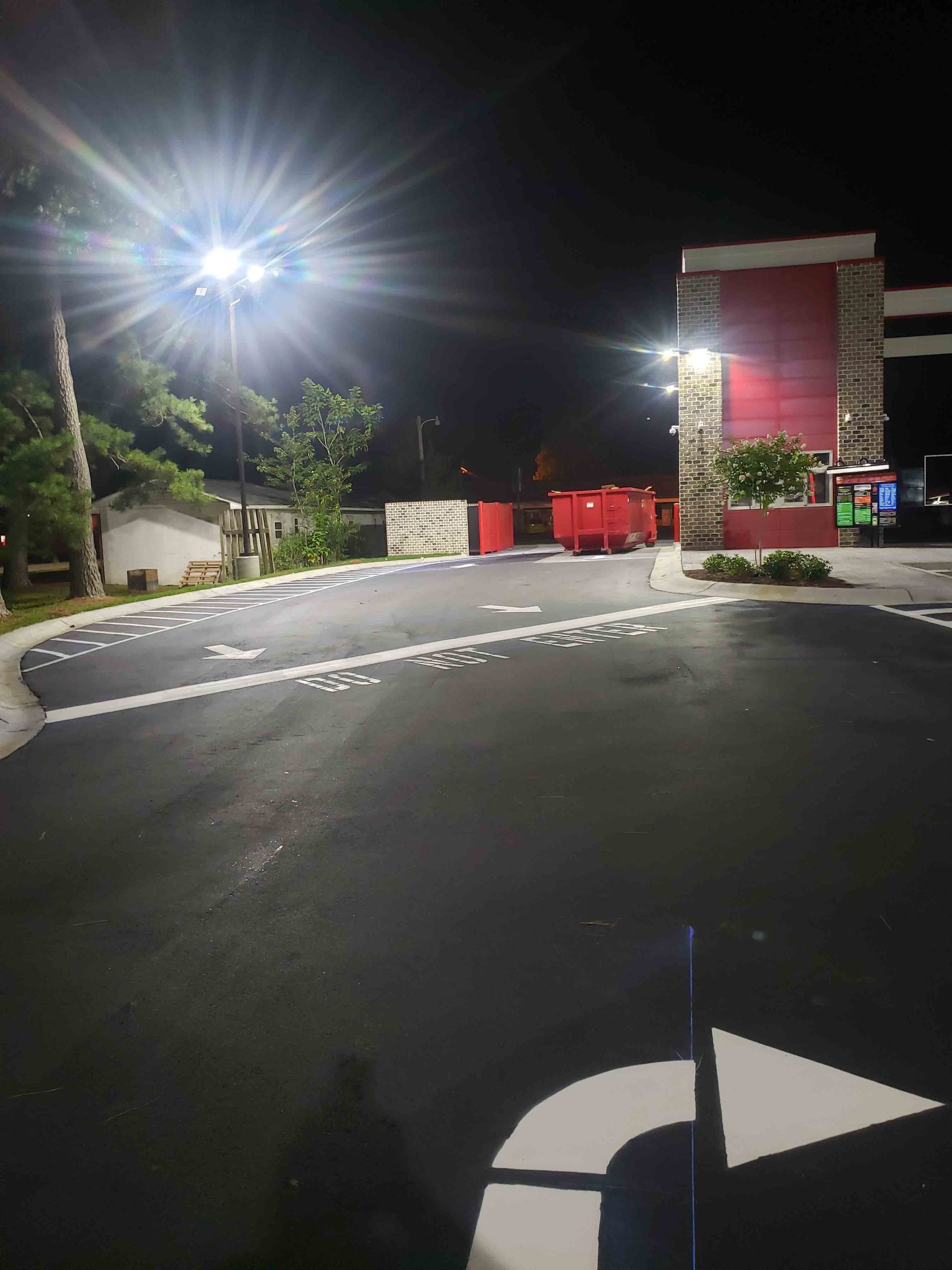 A parking lot with an arrow pointing to the right at night