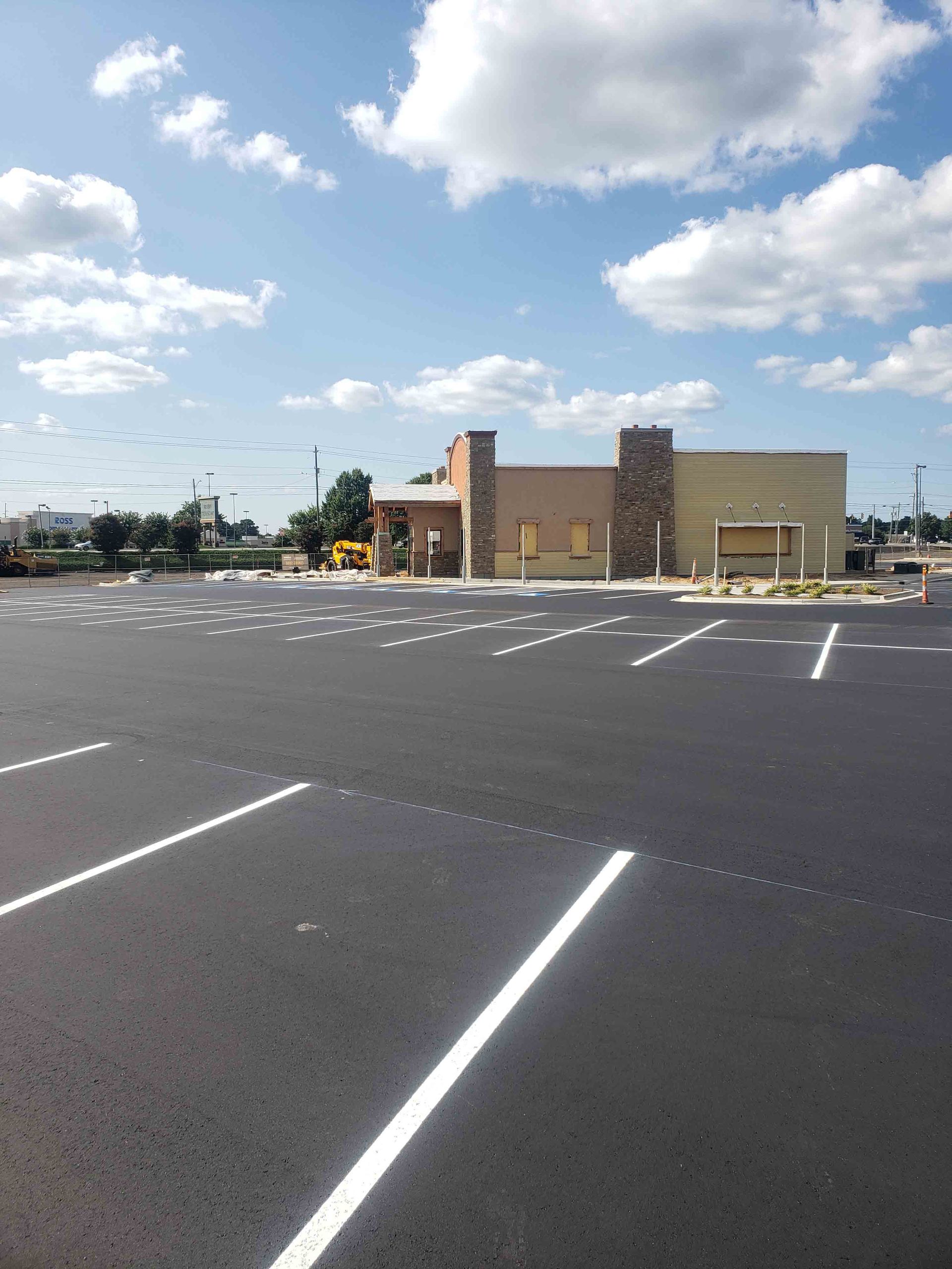 An empty parking lot with a building in the background