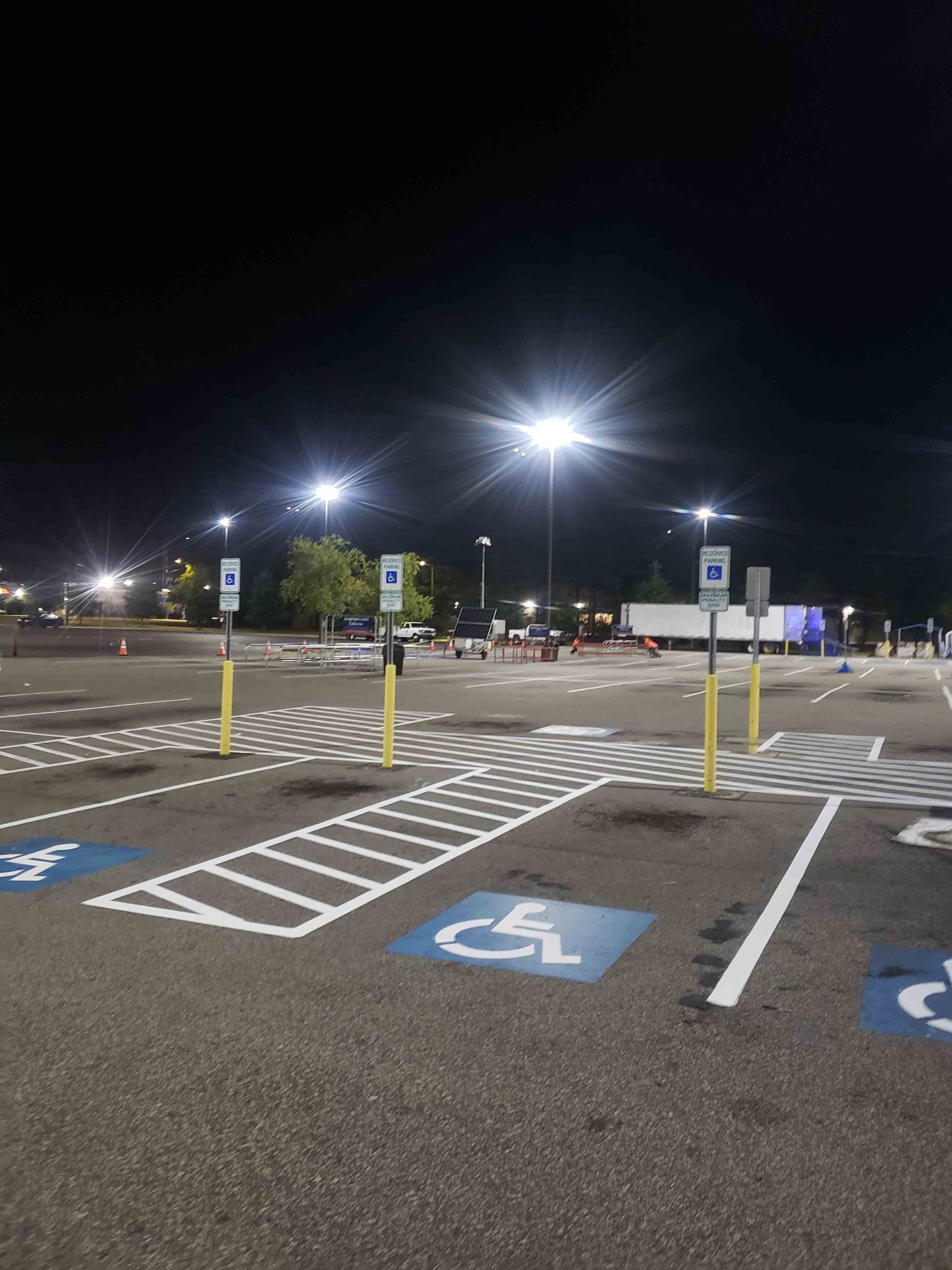 A handicapped parking spot in a parking lot at night
