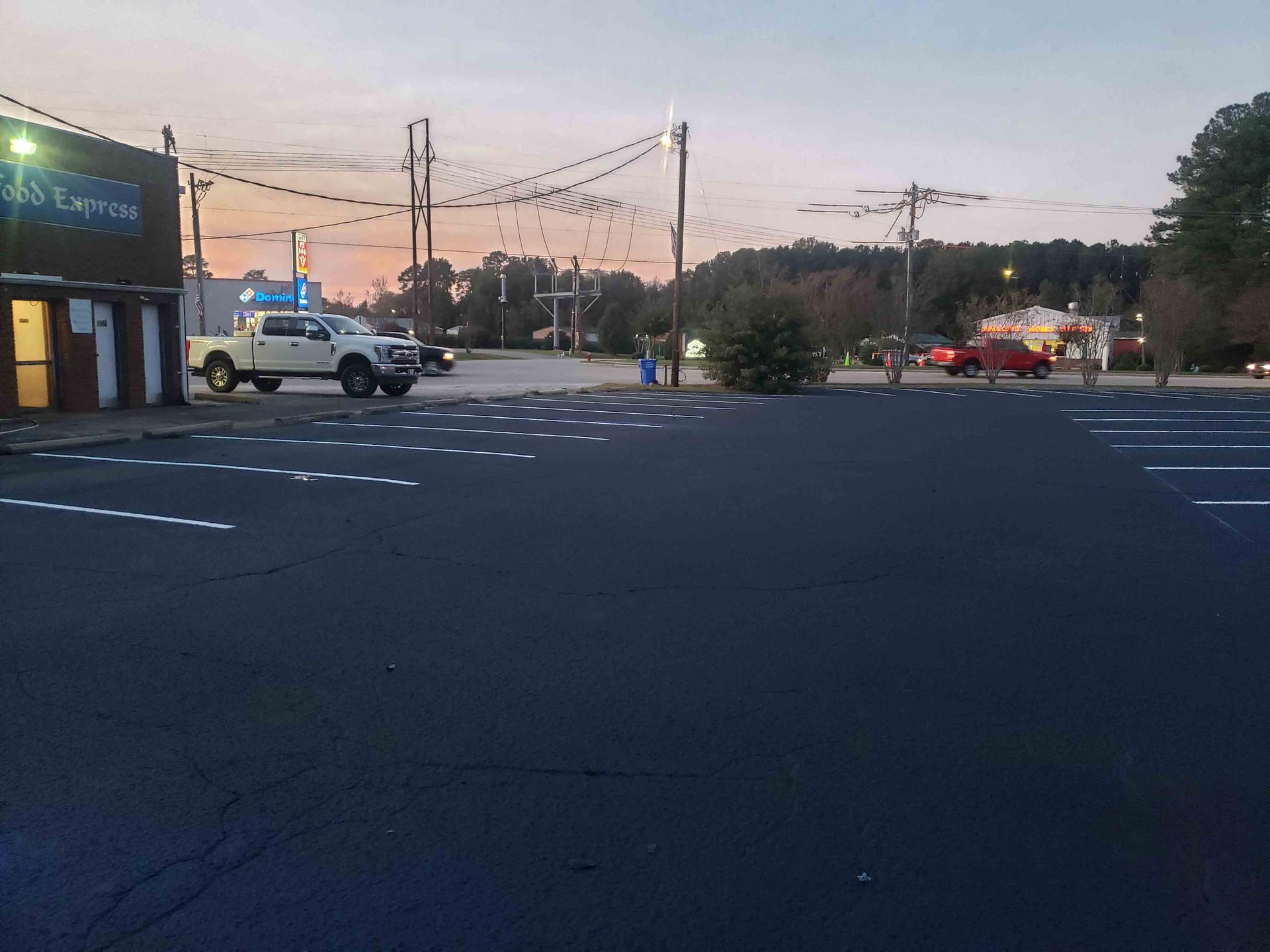 A white truck is parked in front of a building that says express