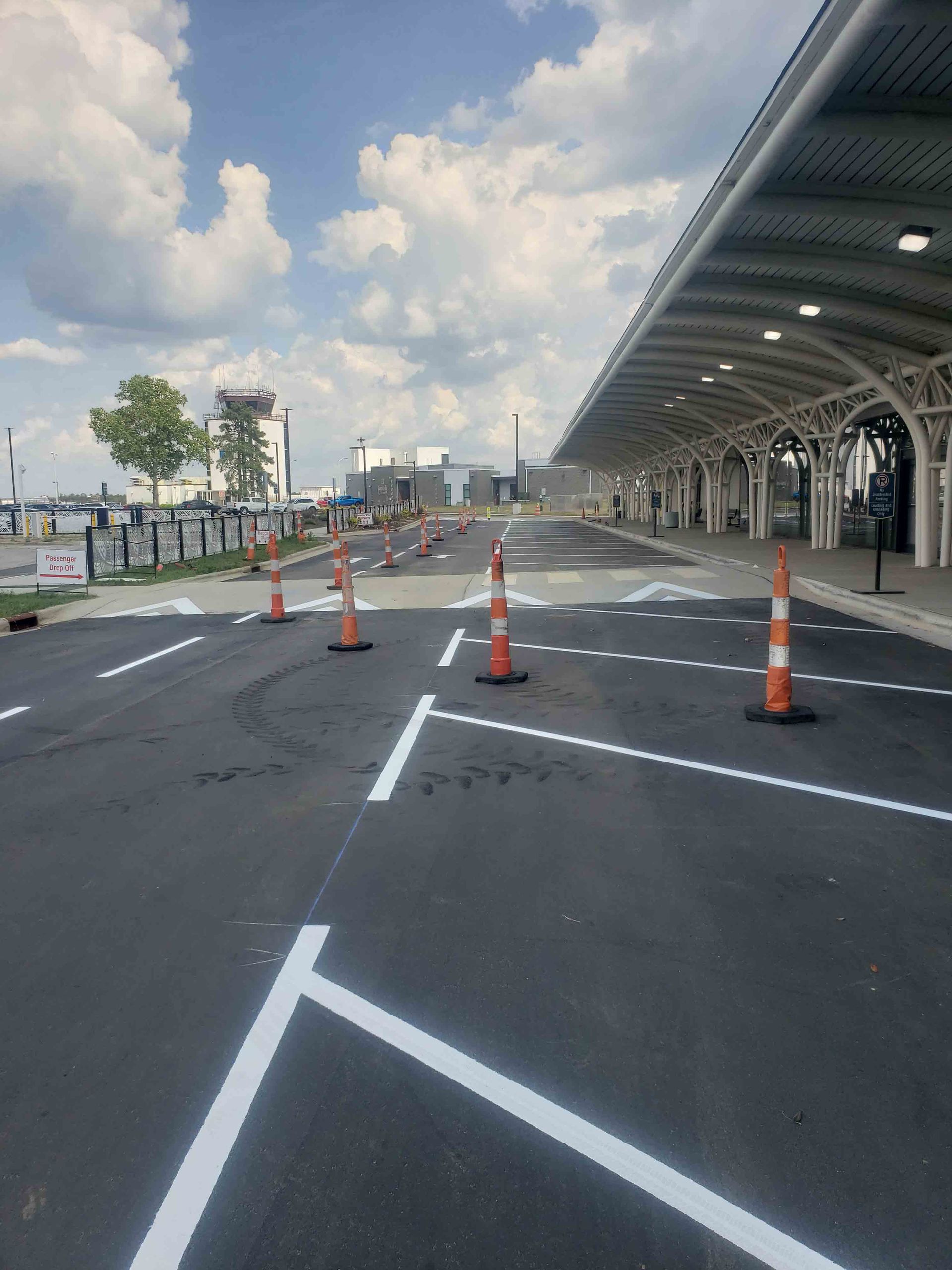 A parking lot with orange cones and white lines on it