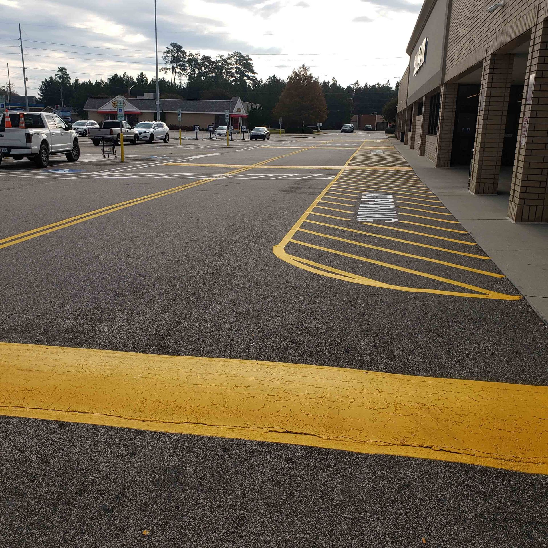 A parking lot in front of a store with a handicapped parking spot