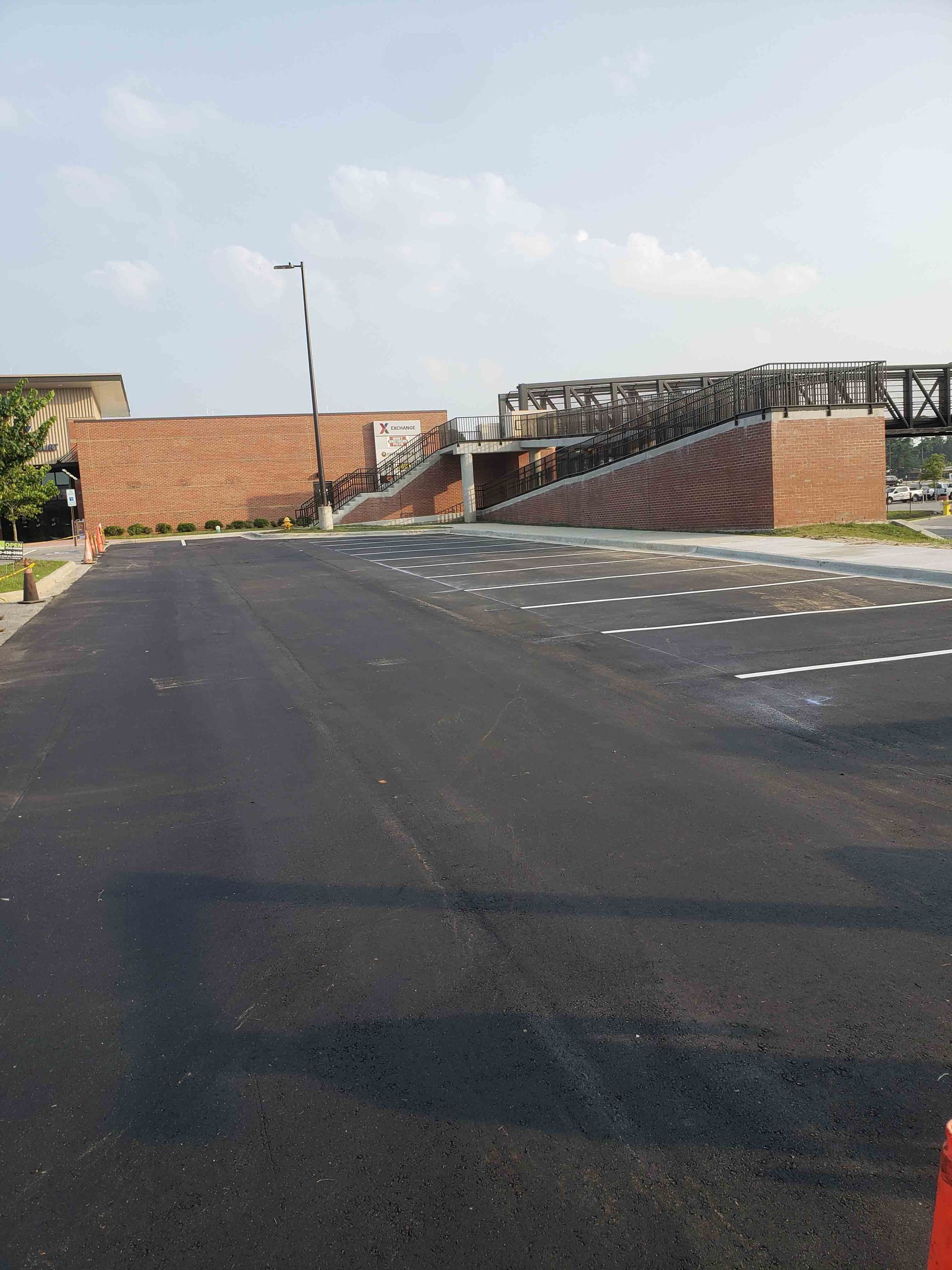 A bridge over a road with a brick building in the background