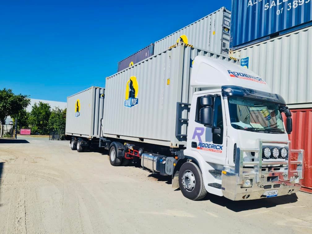 Truck With a Trailer is Parked in Front of a Shipping Container — Roderick Removals & Van Lines In Gladstone Central, QLD
