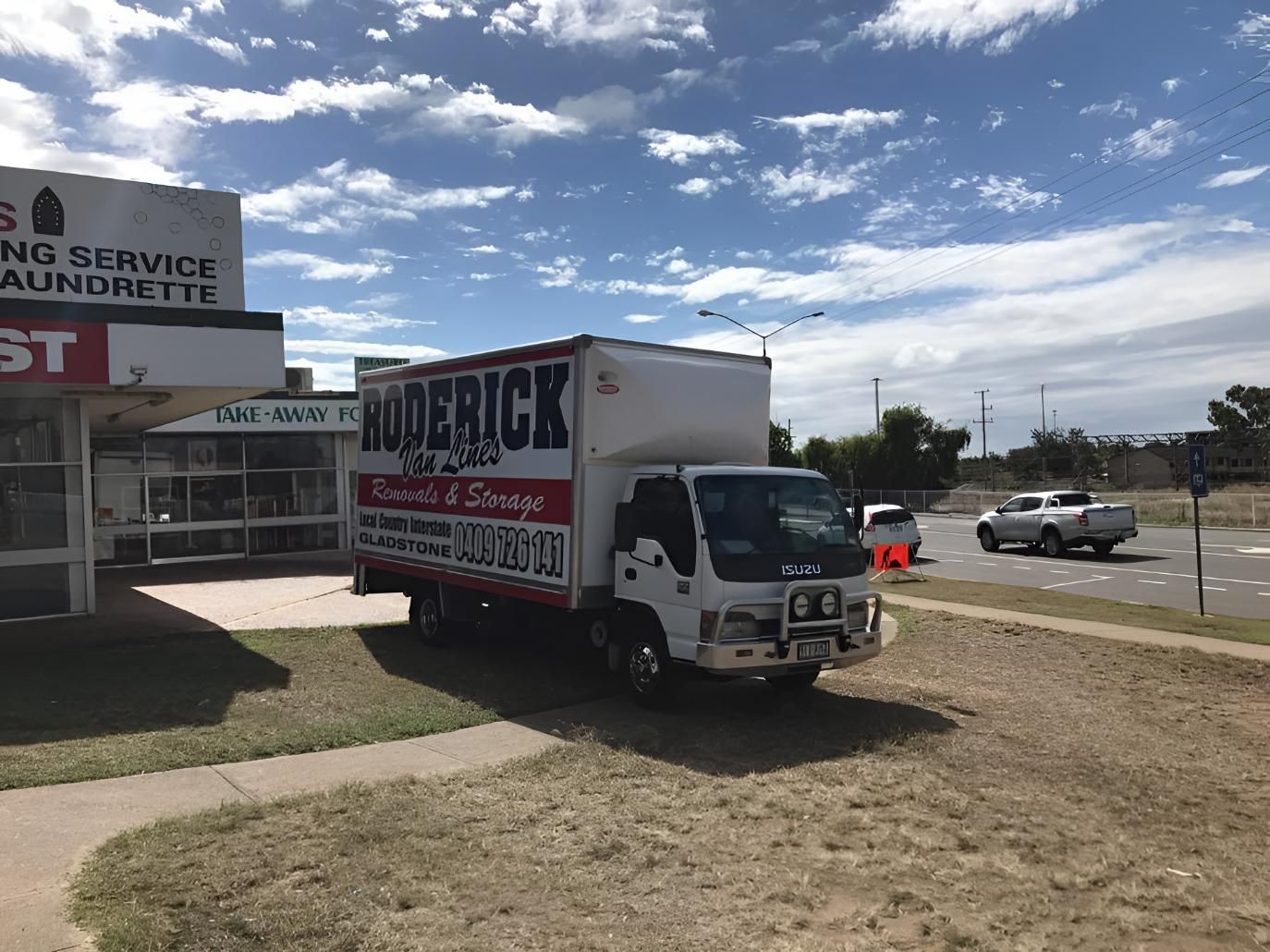 A Moving Truck is Parked in Front of a Building — Roderick Removals & Van Lines In Tannum Sands, QLD