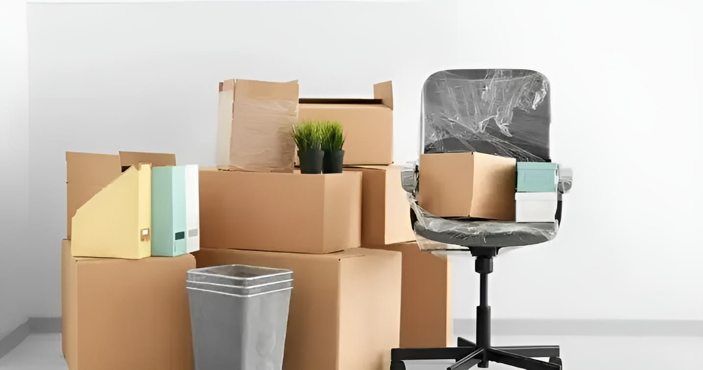 A Chair is Sitting Next to a Pile of Cardboard Boxes — Roderick Removals & Van Lines In Moura, NSW