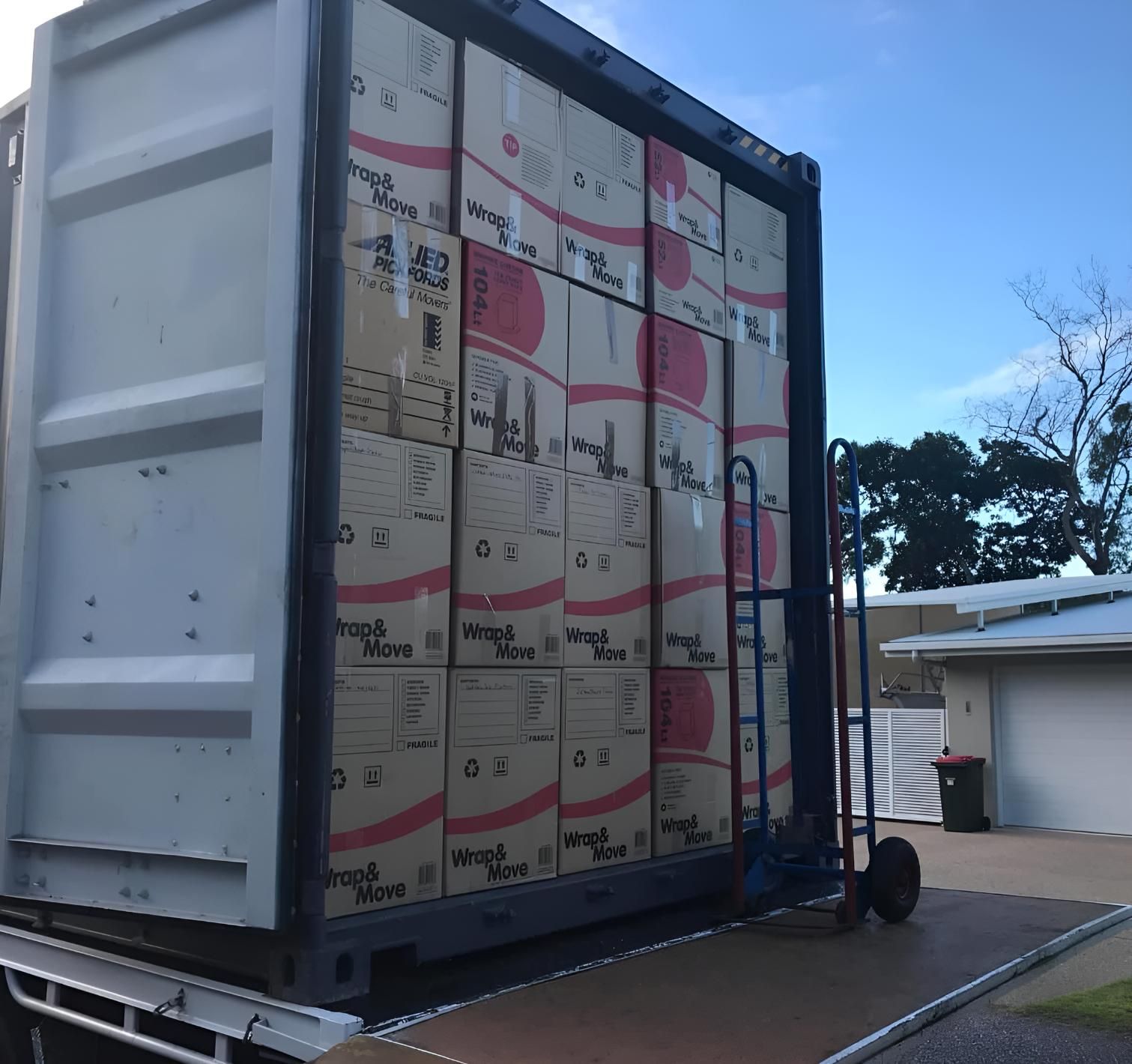 A Large Shipping Container Filled With Boxes and a Cart — Roderick Removals & Van Lines In Sunshine Coast, QLD