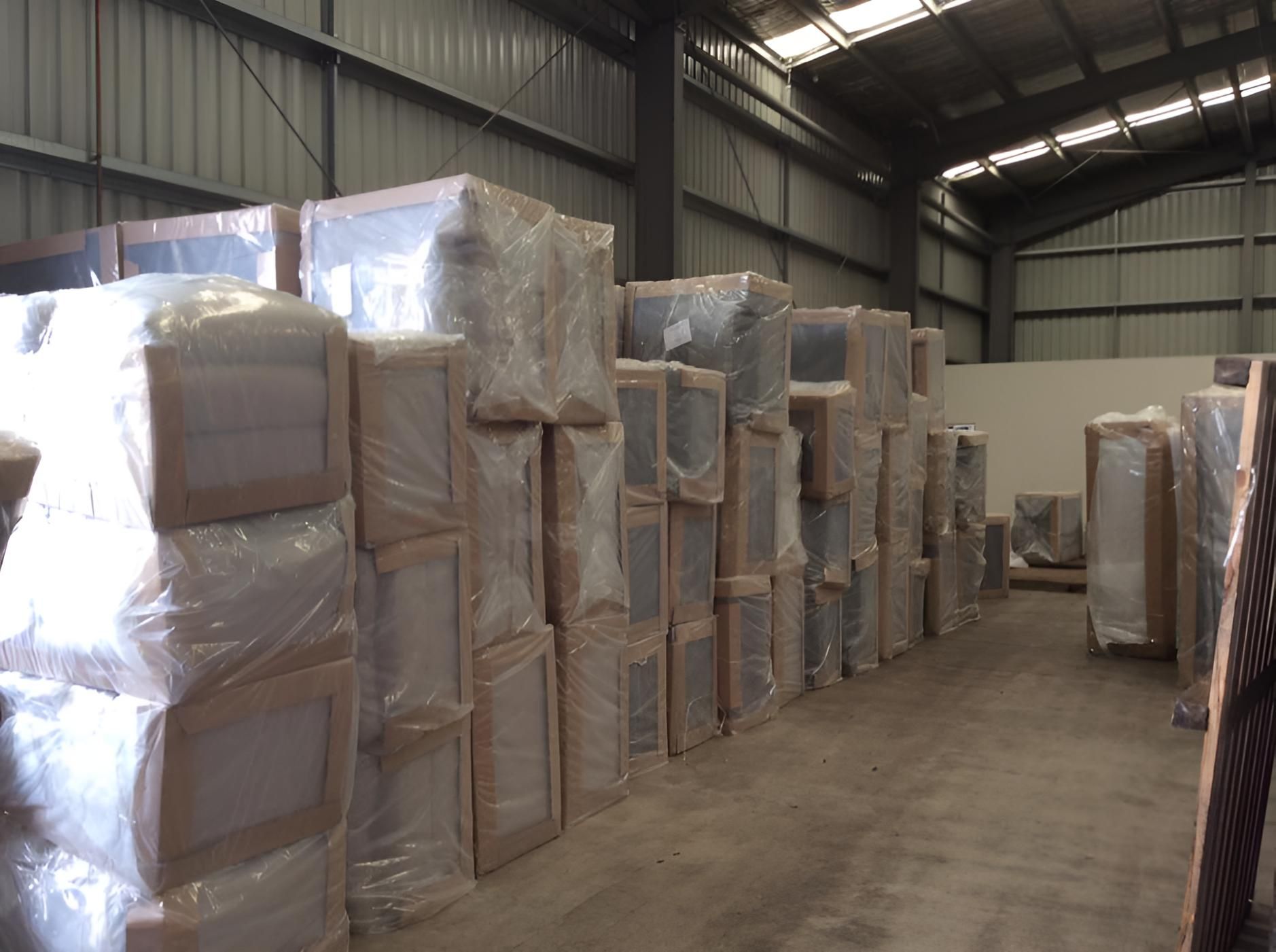 A Warehouse Filled With Lots of Boxes Wrapped in Plastic — Roderick Removals & Van Lines In Mackay, QLD