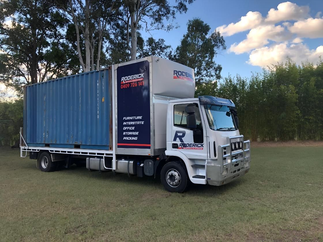 Semi Truck With a Black Container on the Back is Parked in a Gravel Lot — Roderick Removals & Van Lines In Emerald, QLD