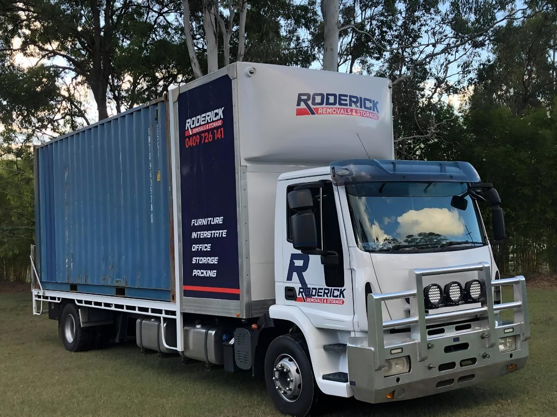 A Roderick Moving Truck is Parked in a Grassy Field — Roderick Removals & Van Lines In Hervey Bay, QLD