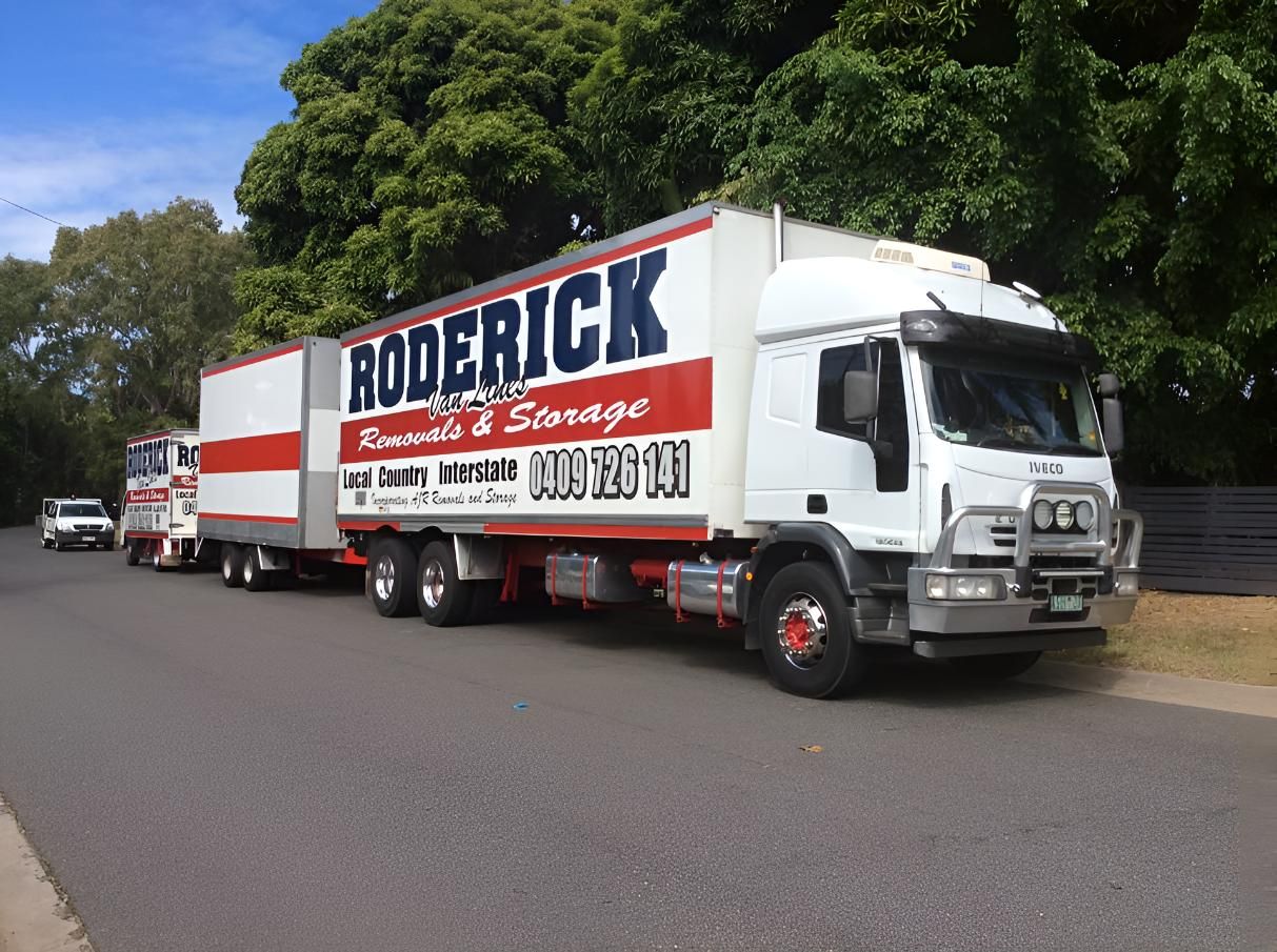 A Row of Roderick Moving Trucks Are Parked on the Side of the Road — Roderick Removals & Van Lines In Rockhampton, QLD