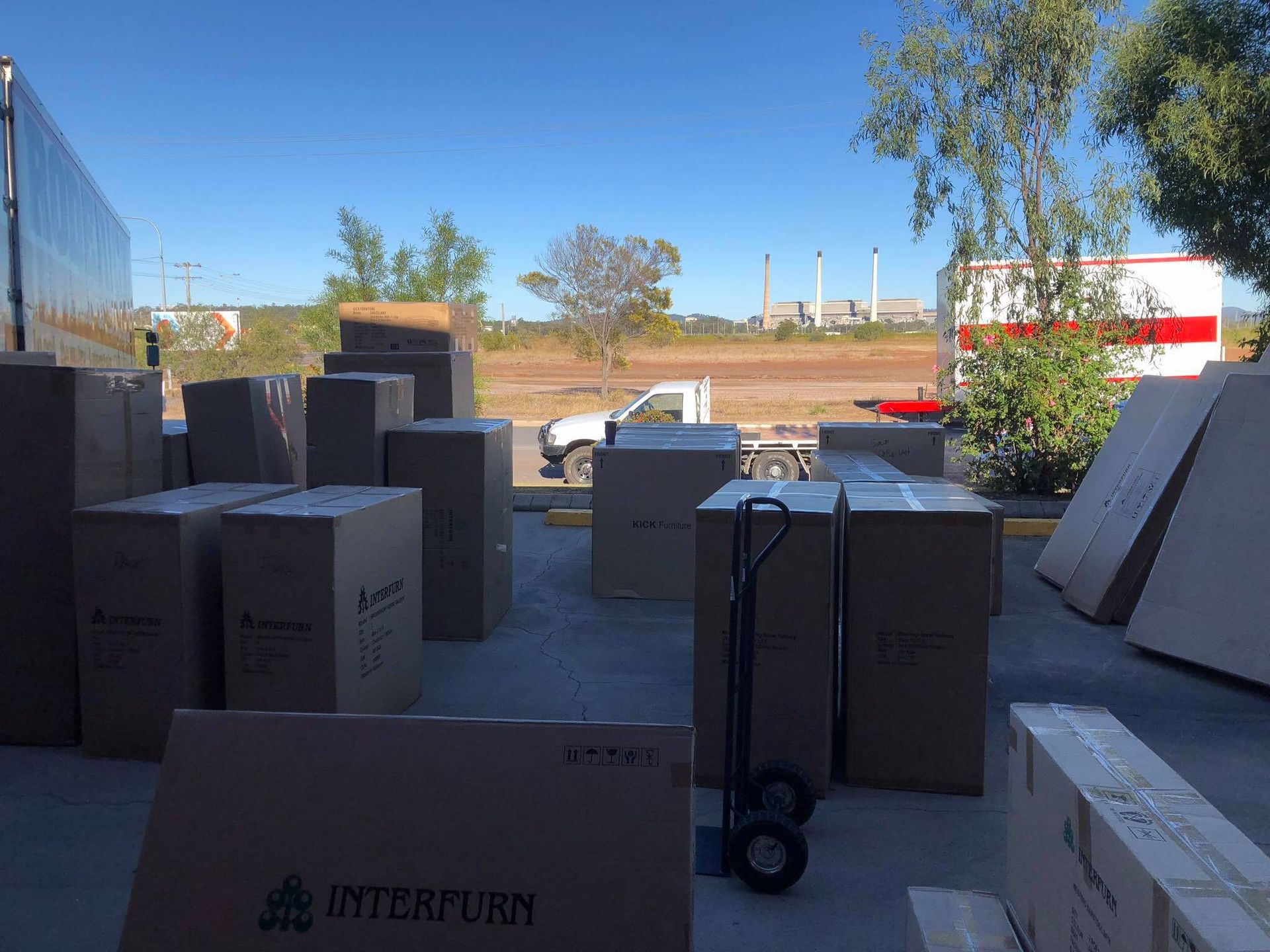 A Moving Truck is Parked in Front of a House with boxes in front of it — Roderick Removals & Van Lines In Cairns, NSW