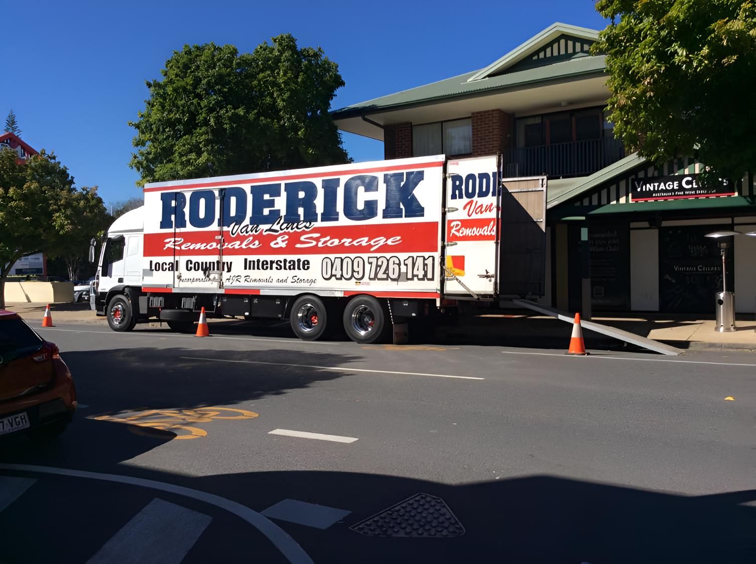 A Roderick Truck is Parked in Front of a Building — Roderick Removals & Van Lines In Gladstone Central, QLD