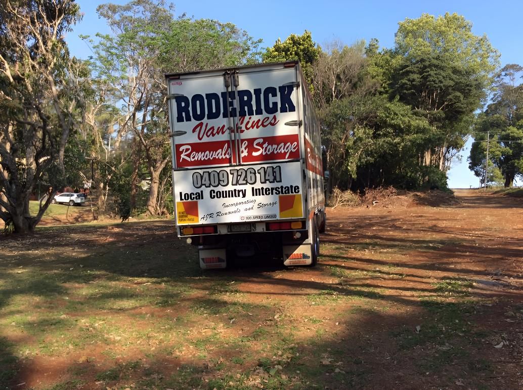 A Roderick Moving Truck is Parked in a Dirt Field — Roderick Removals & Van Lines In Gladstone Central, QLD