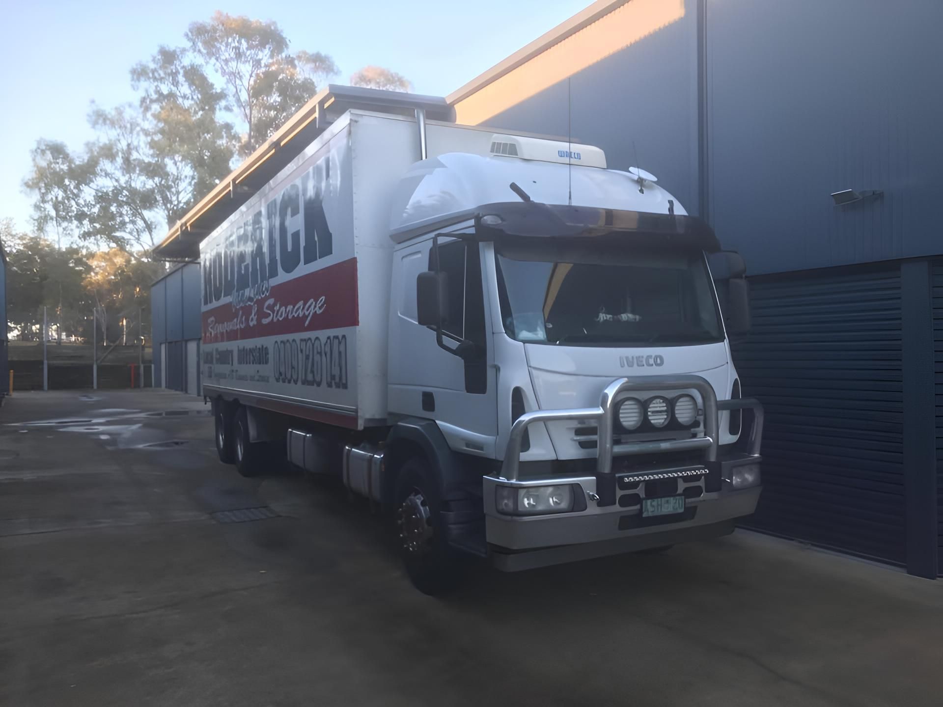 A White Truck is Parked in Front of a Building — Roderick Removals & Van Lines In Cairns, NSW