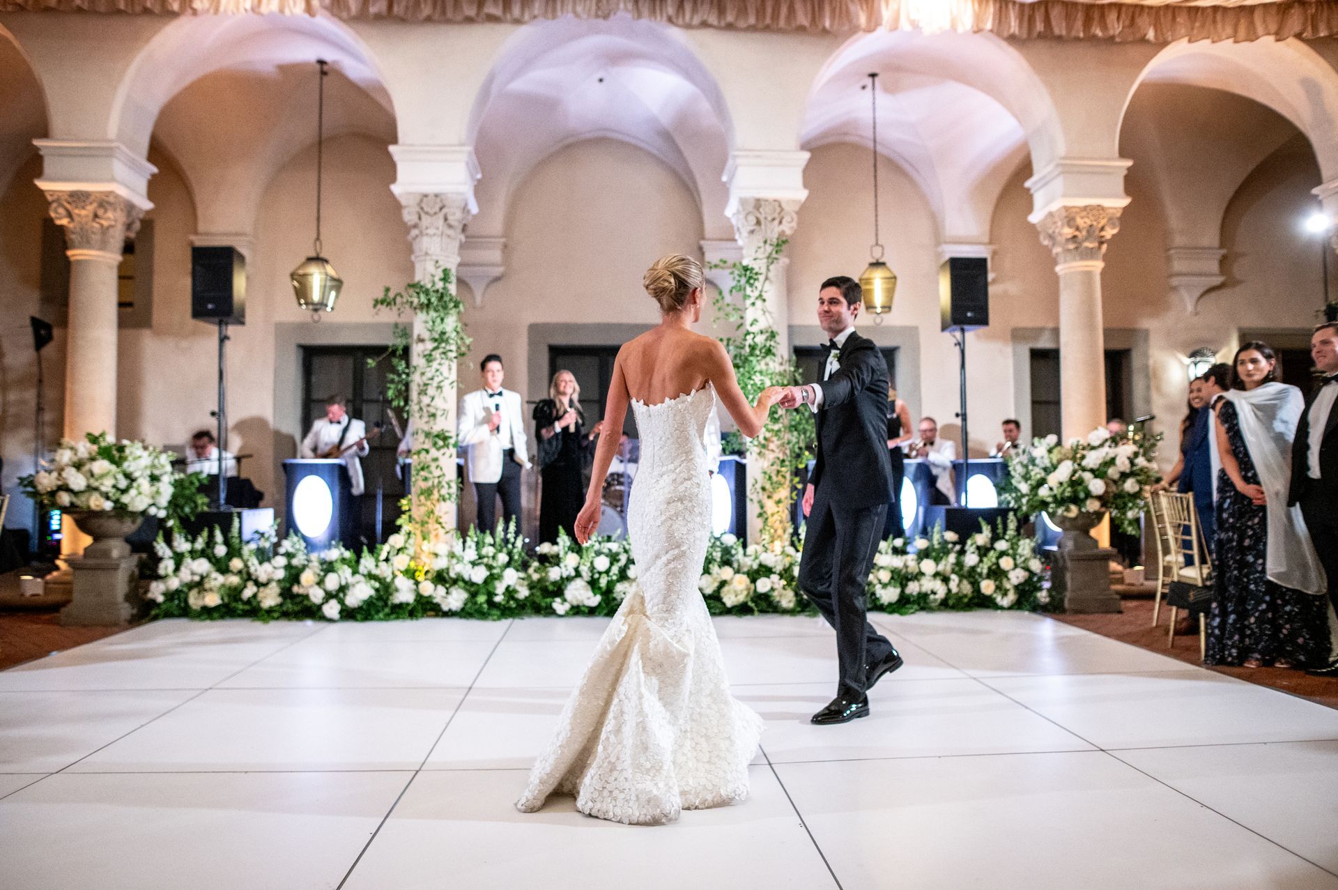 married couple dances in front of wedding live band