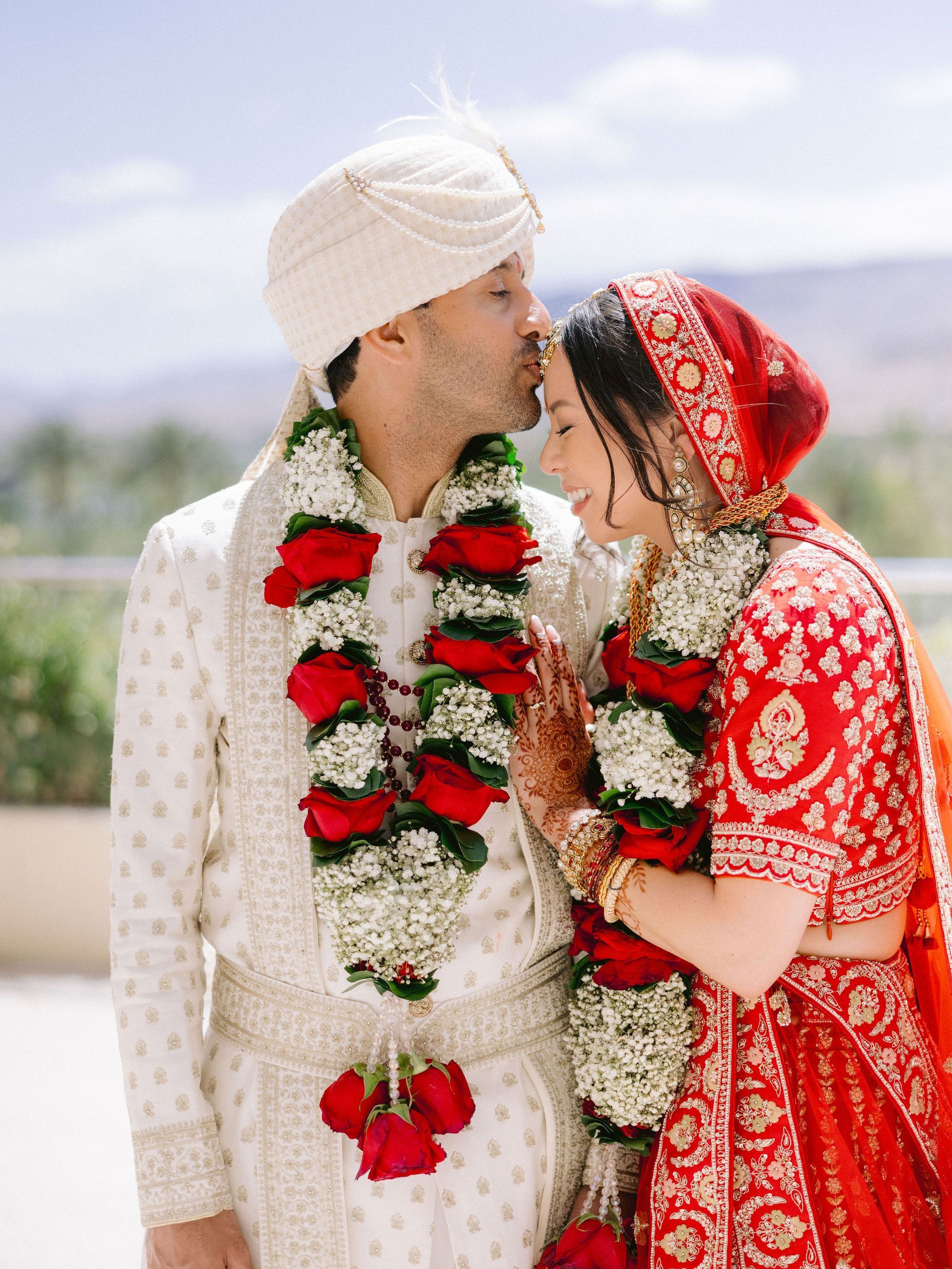 A bride and groom are kissing each other on their wedding day.