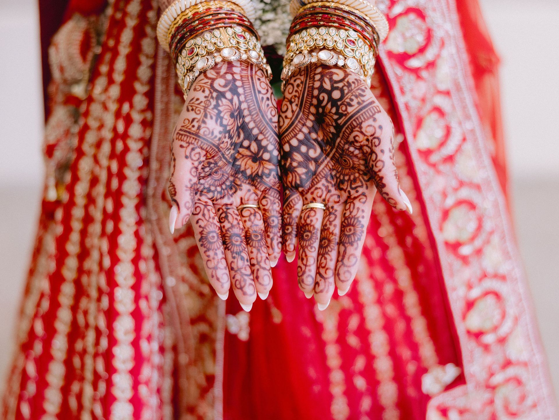 A close up of a bride 's hands with henna on them.