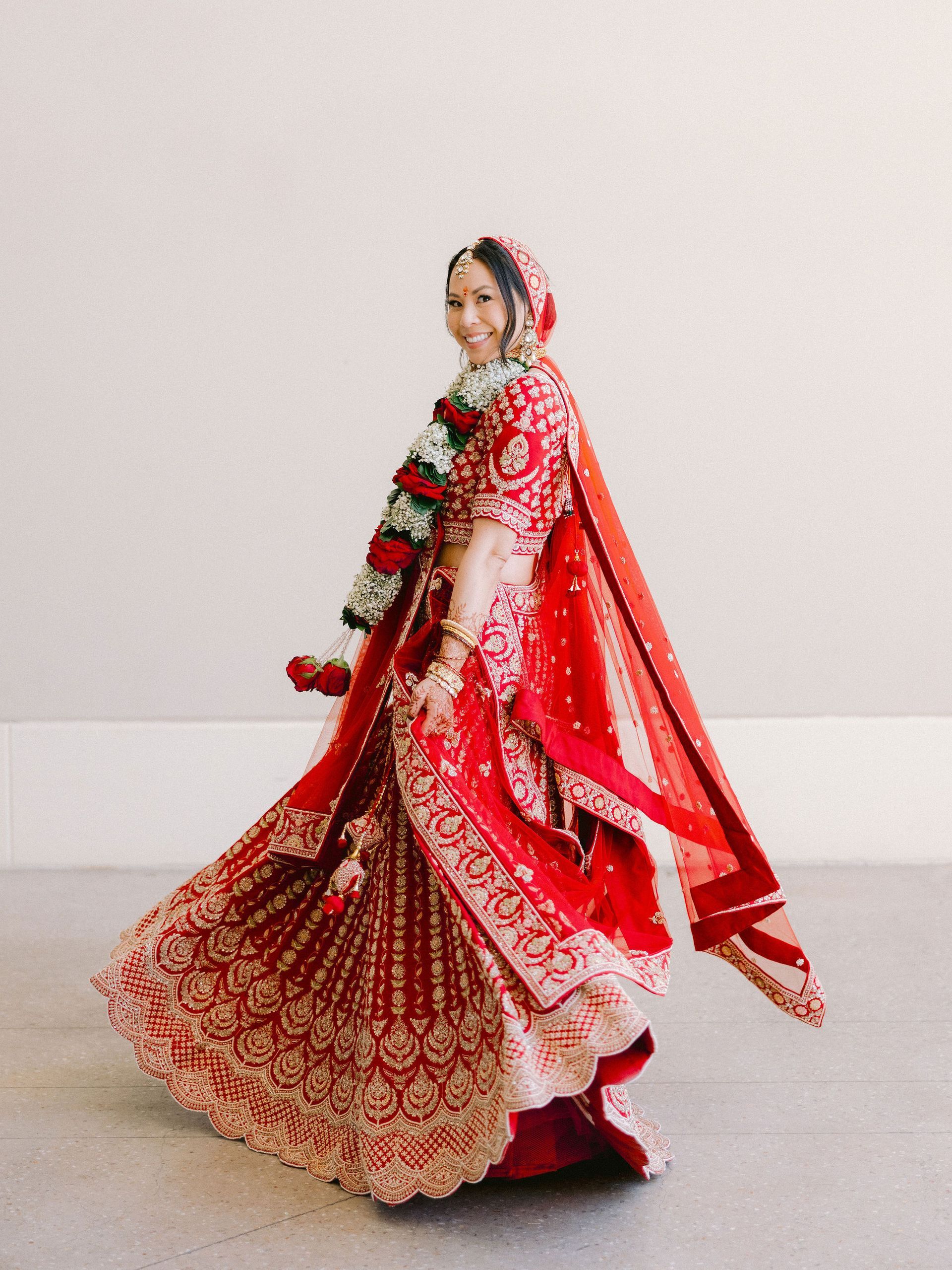 A woman in a red and gold dress is dancing.