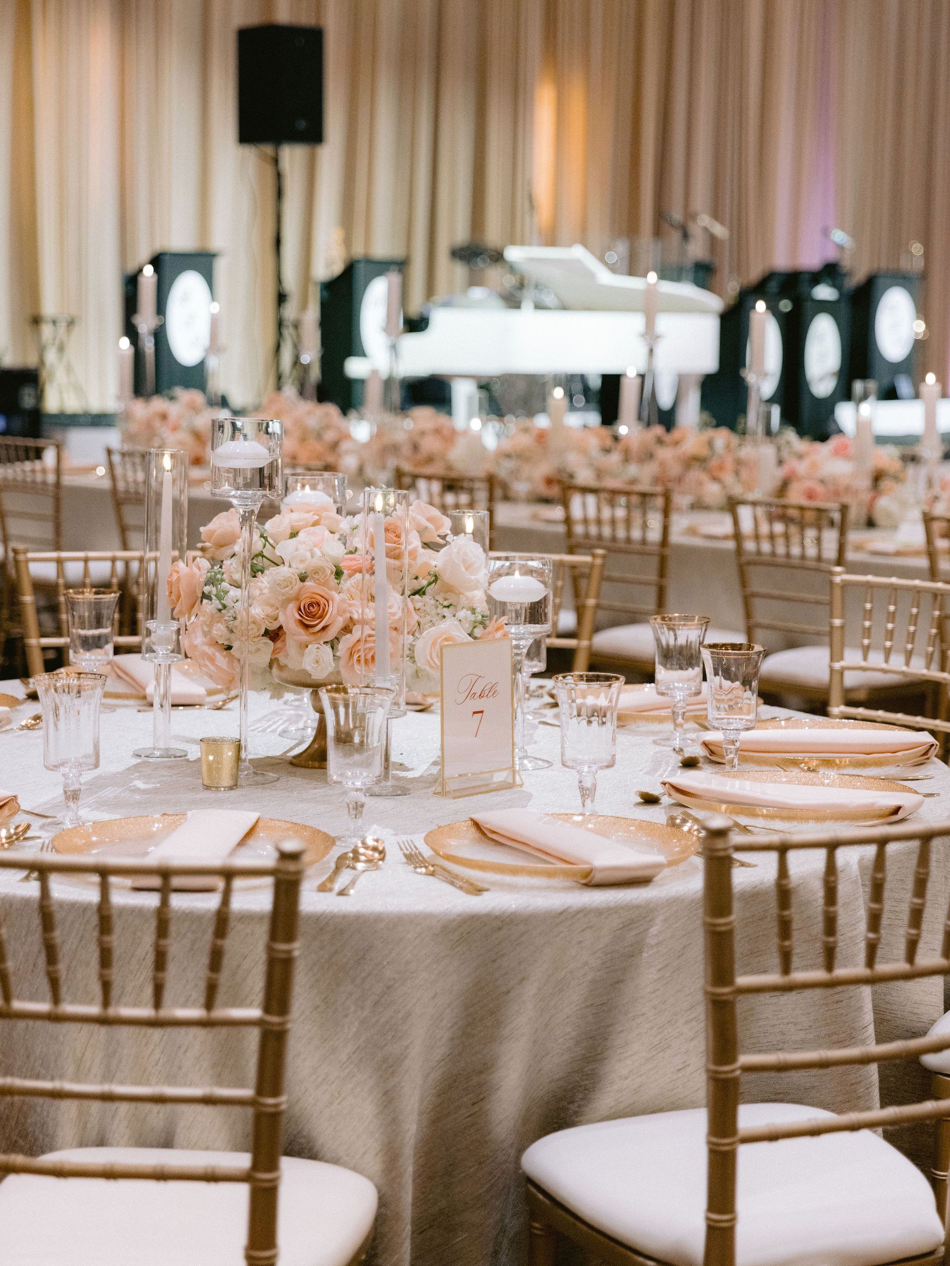 A large room with tables and chairs set up for a wedding reception.