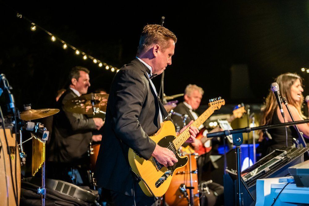 Guitarist and other performers at a private event