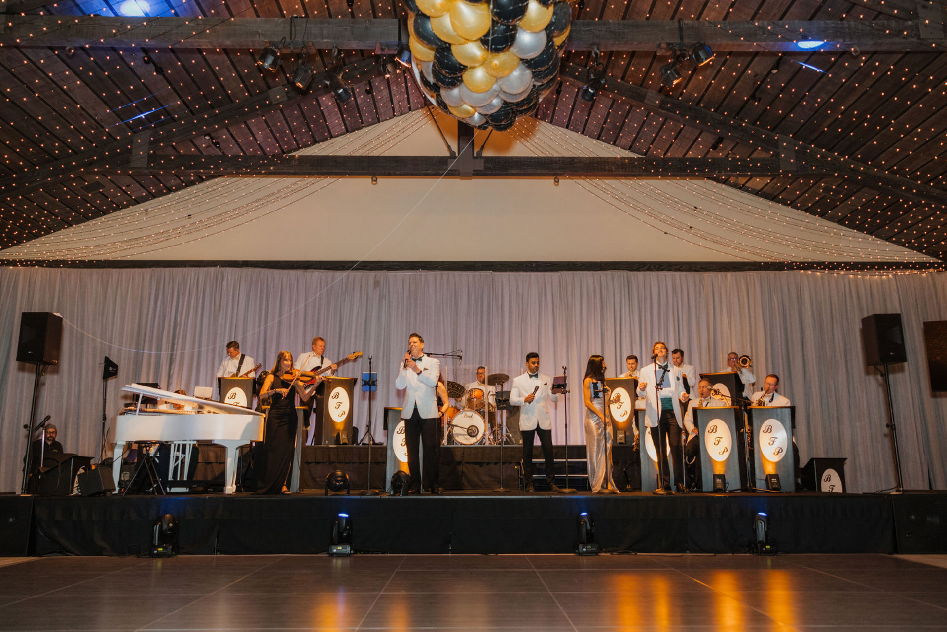 A group of people are standing on a stage playing instruments.