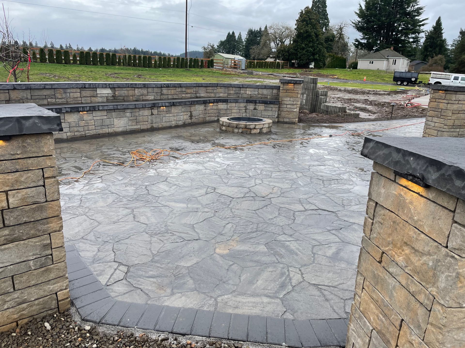 Empty stone patio with low walls and pillars in a rural outdoor setting