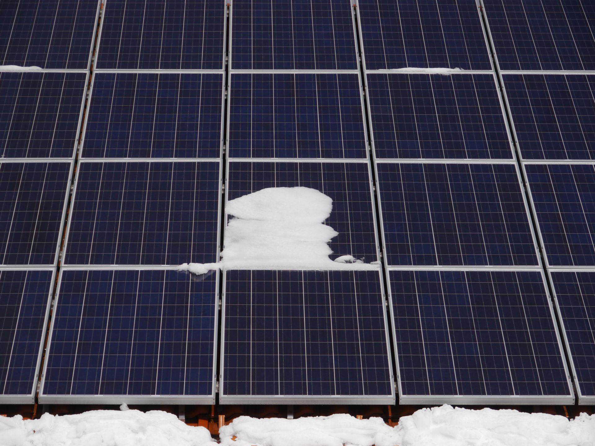 Damaged solar panel with white patch on dark blue photovoltaic cells