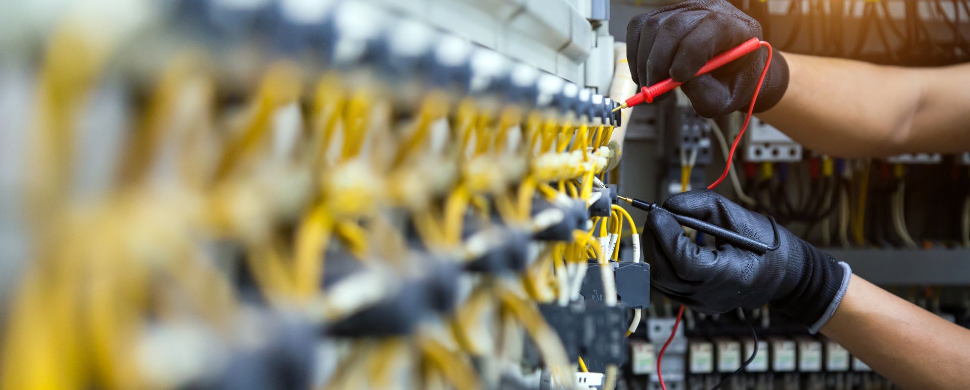 Technician testing network cables with a multimeter in a server room