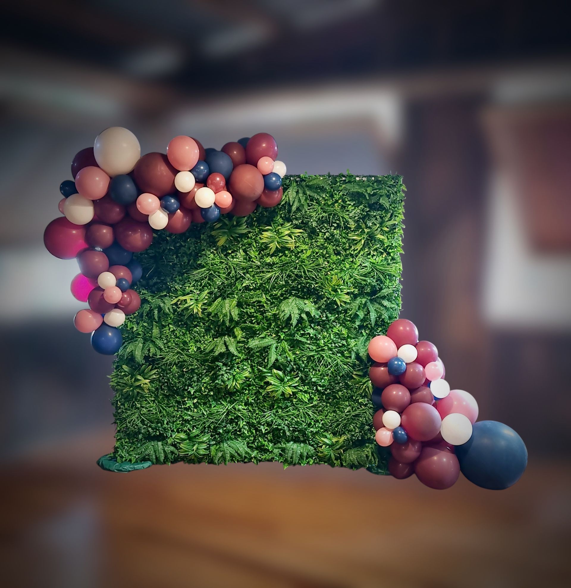 Tropical greenery wall with balloons attached