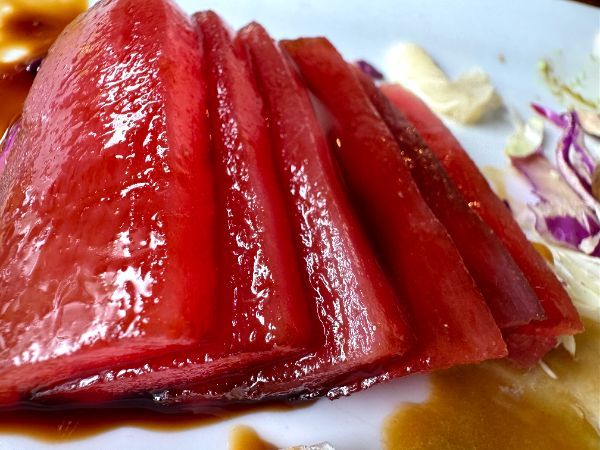 A close-up of sliced sushi on a white plate