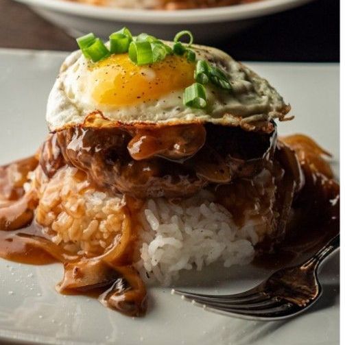 A plate of food with rice and a fried egg on top