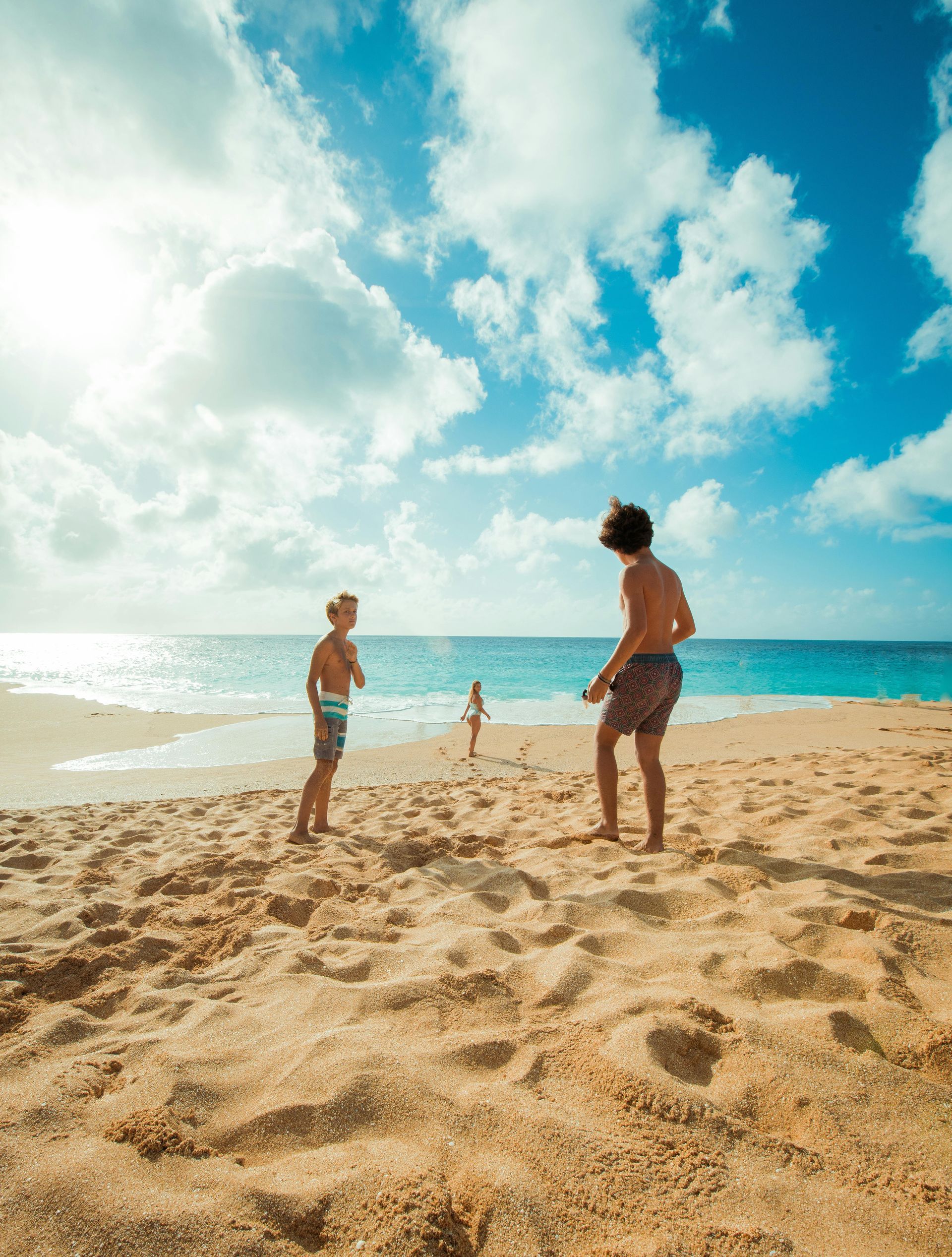Two men are playing frisbee on the beach.