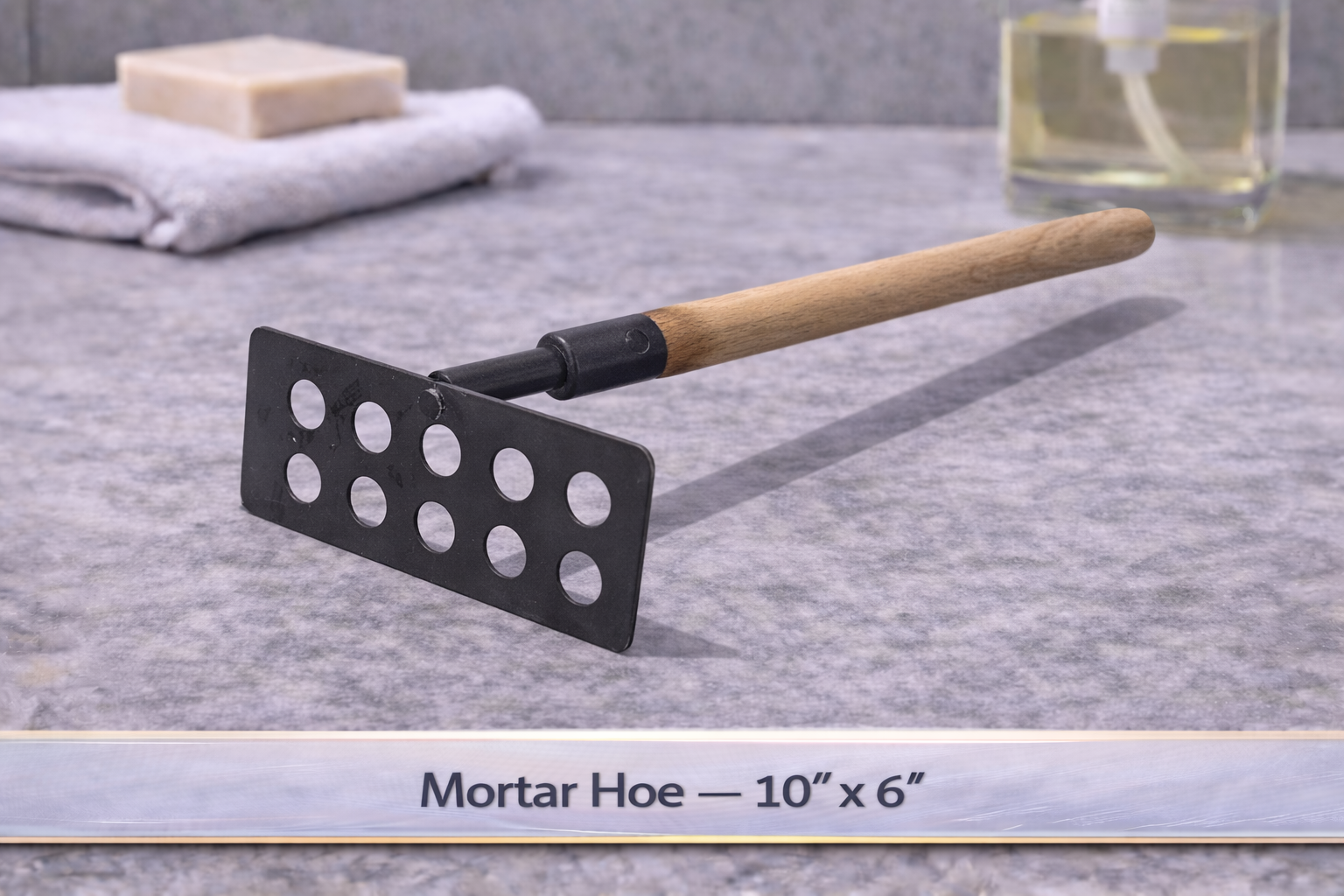 Black mortar hoe with wooden handle on a gray tabletop, labeled “Mortar Hoe — 10” x 6””