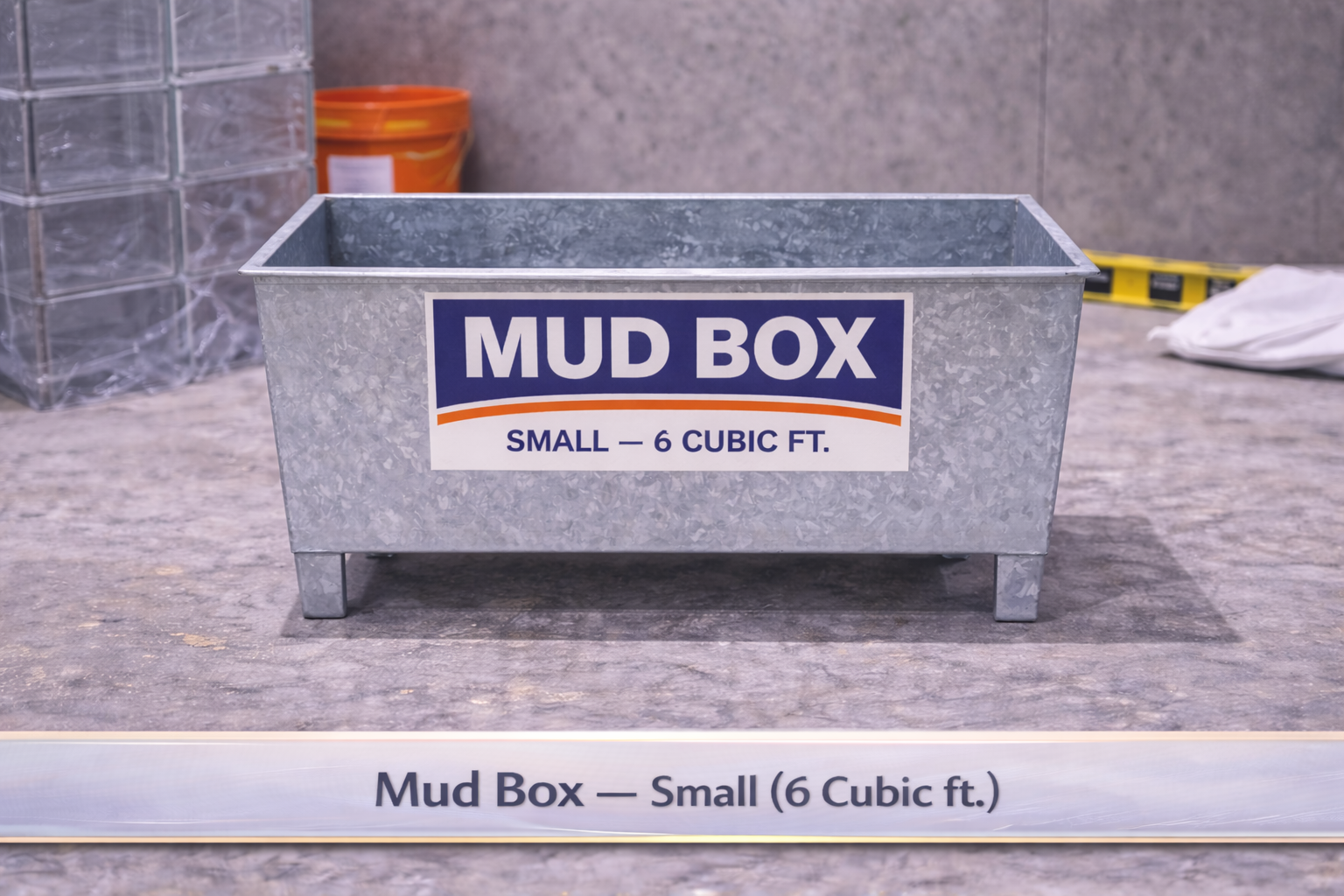 Small gray metal mud box labeled “MUD BOX” on a concrete floor
