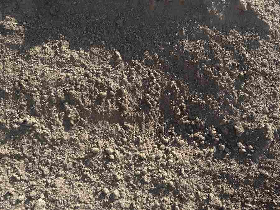 Close-up of rough brown and gray soil with small pebbles and clumps.