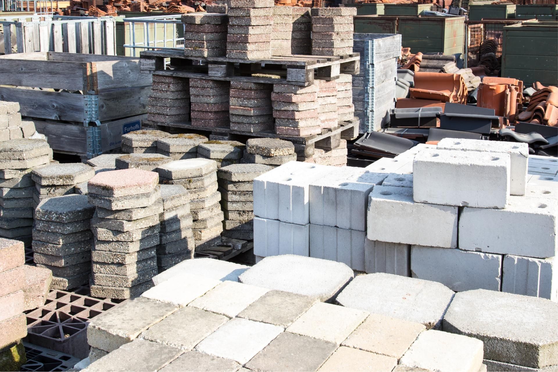Stacks of concrete pavers and blocks in an outdoor строитель materials yard