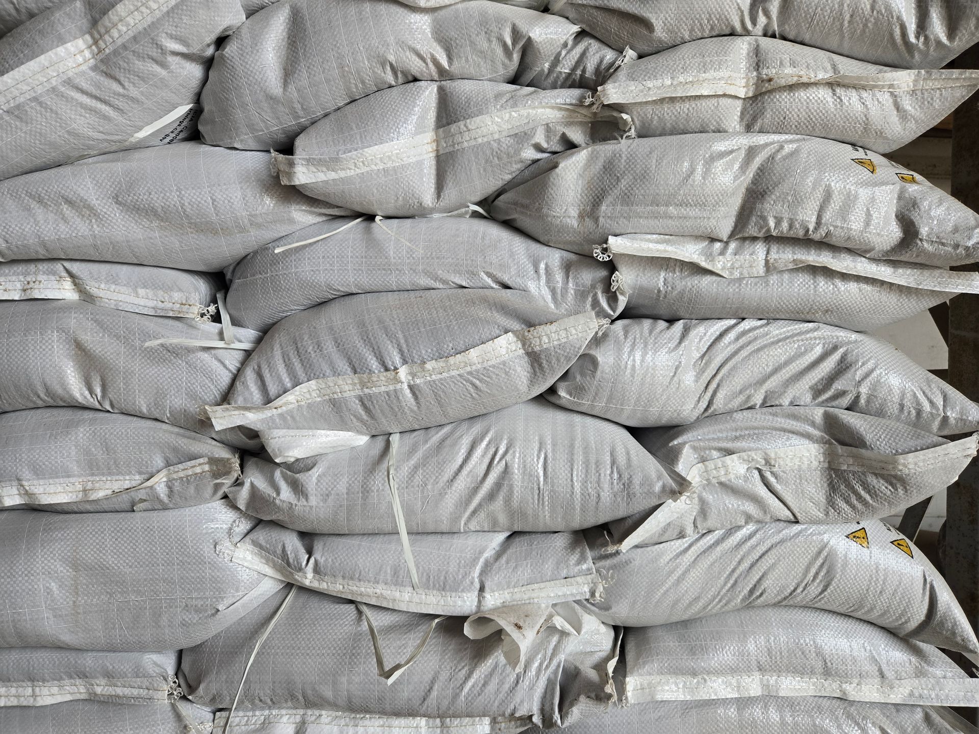 Stacked gray sandbags piled in rows, filling the frame.