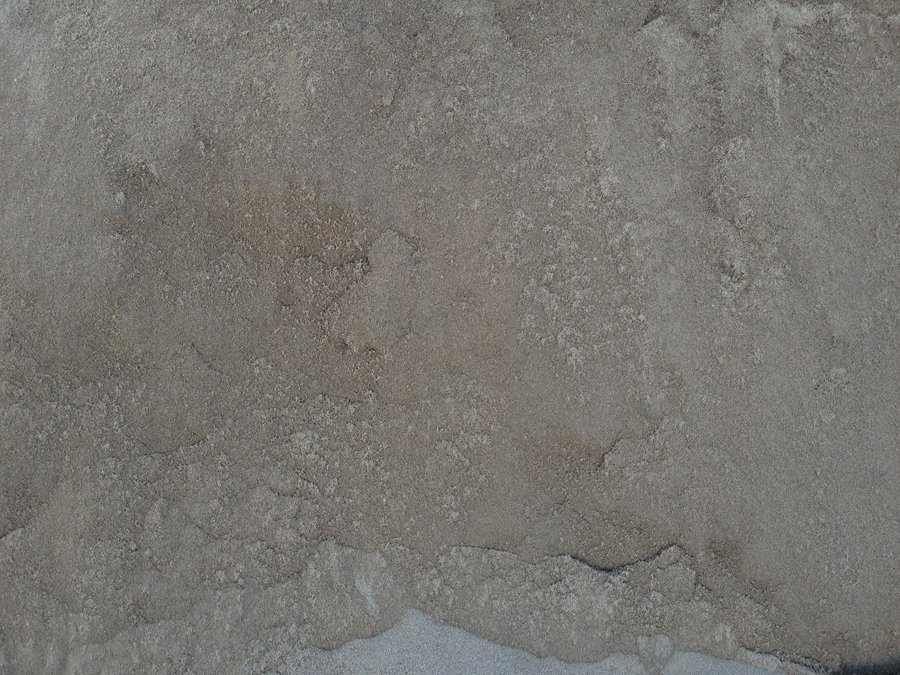 Close-up of a rough gray concrete surface with subtle cracks and stains