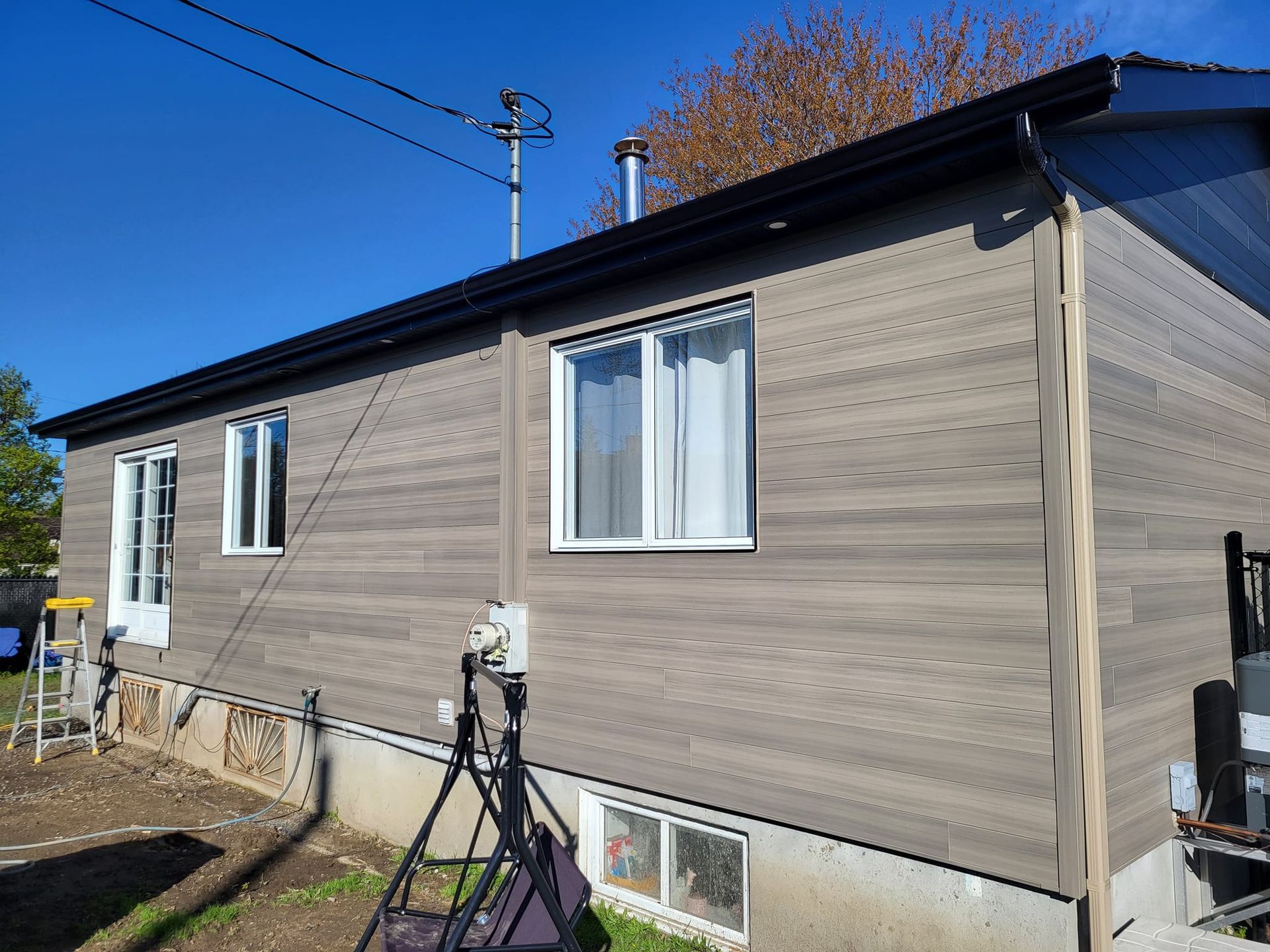 Une petite maison avec une balançoire devant