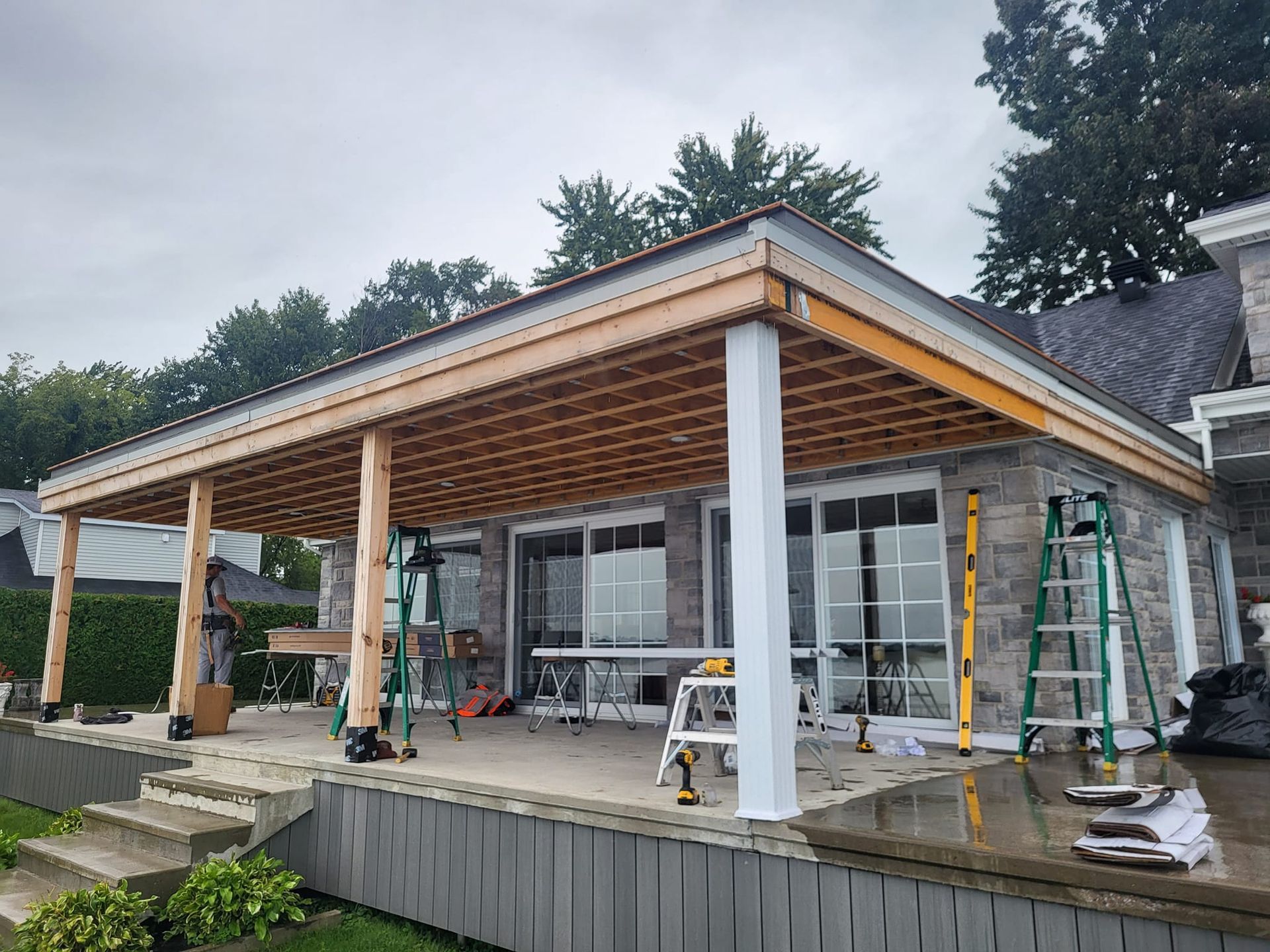 Une maison avec un porche couvert en construction sur le côté.