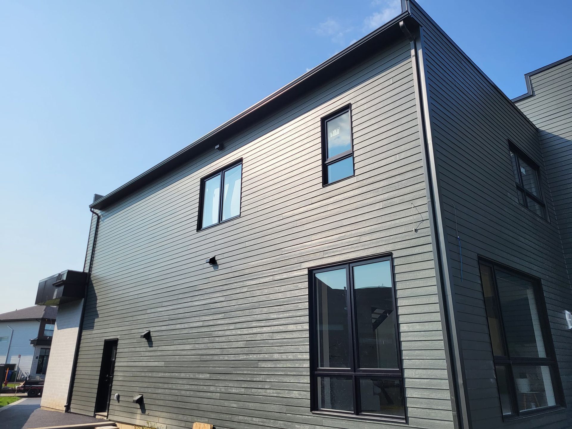 Une grande maison avec beaucoup de fenêtres et un ciel bleu en arrière-plan.