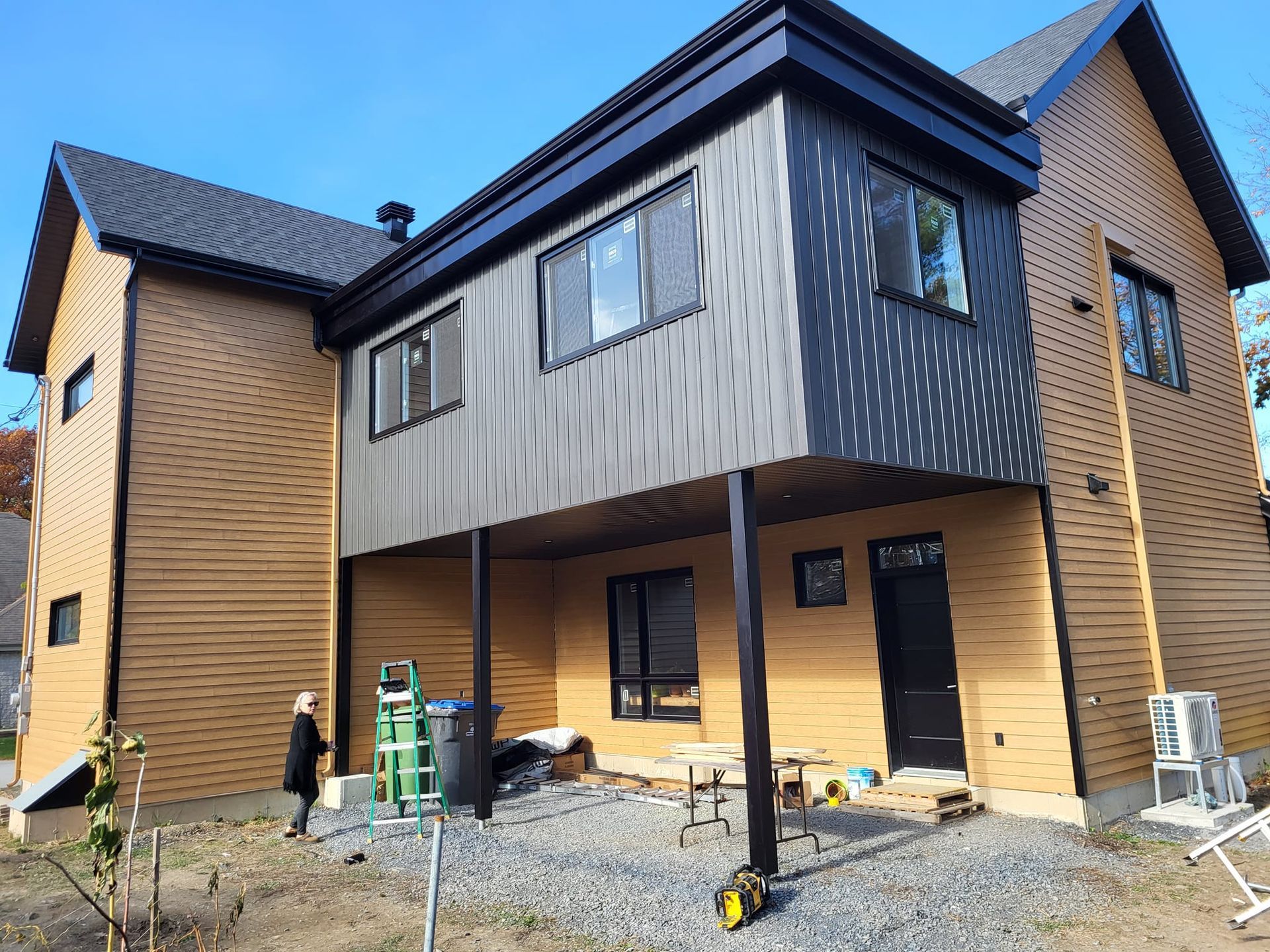 Une grande maison avec beaucoup de fenêtres est en construction.