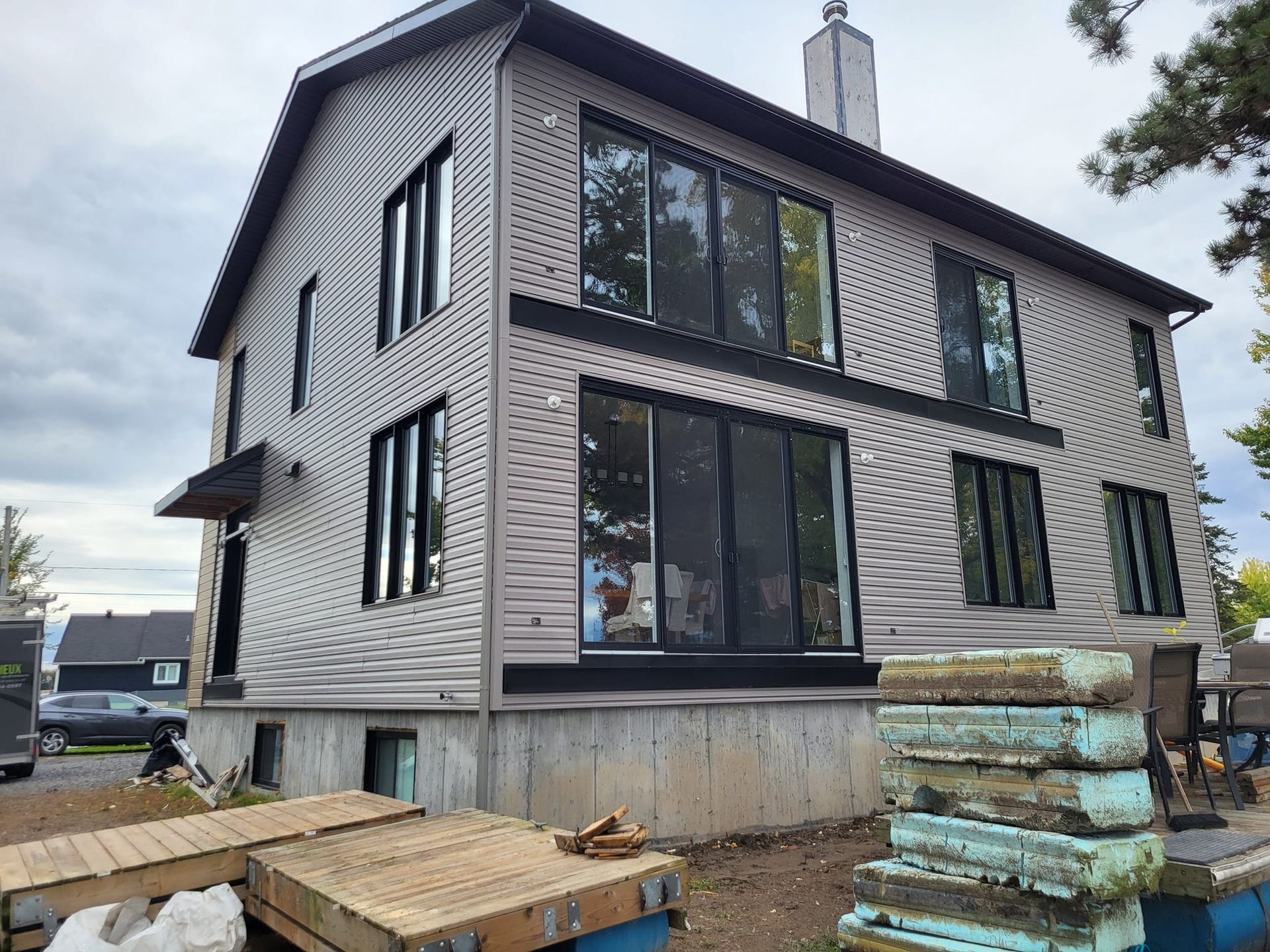 Une grande maison avec beaucoup de fenêtres est en construction.