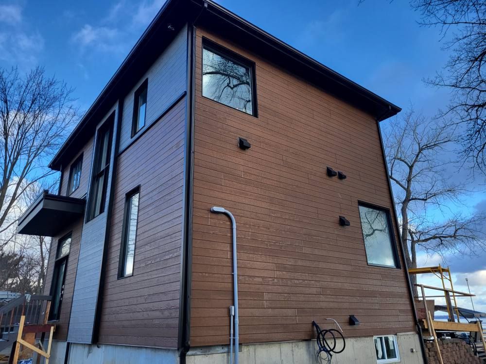 Une grande maison avec beaucoup de fenêtres est en construction.