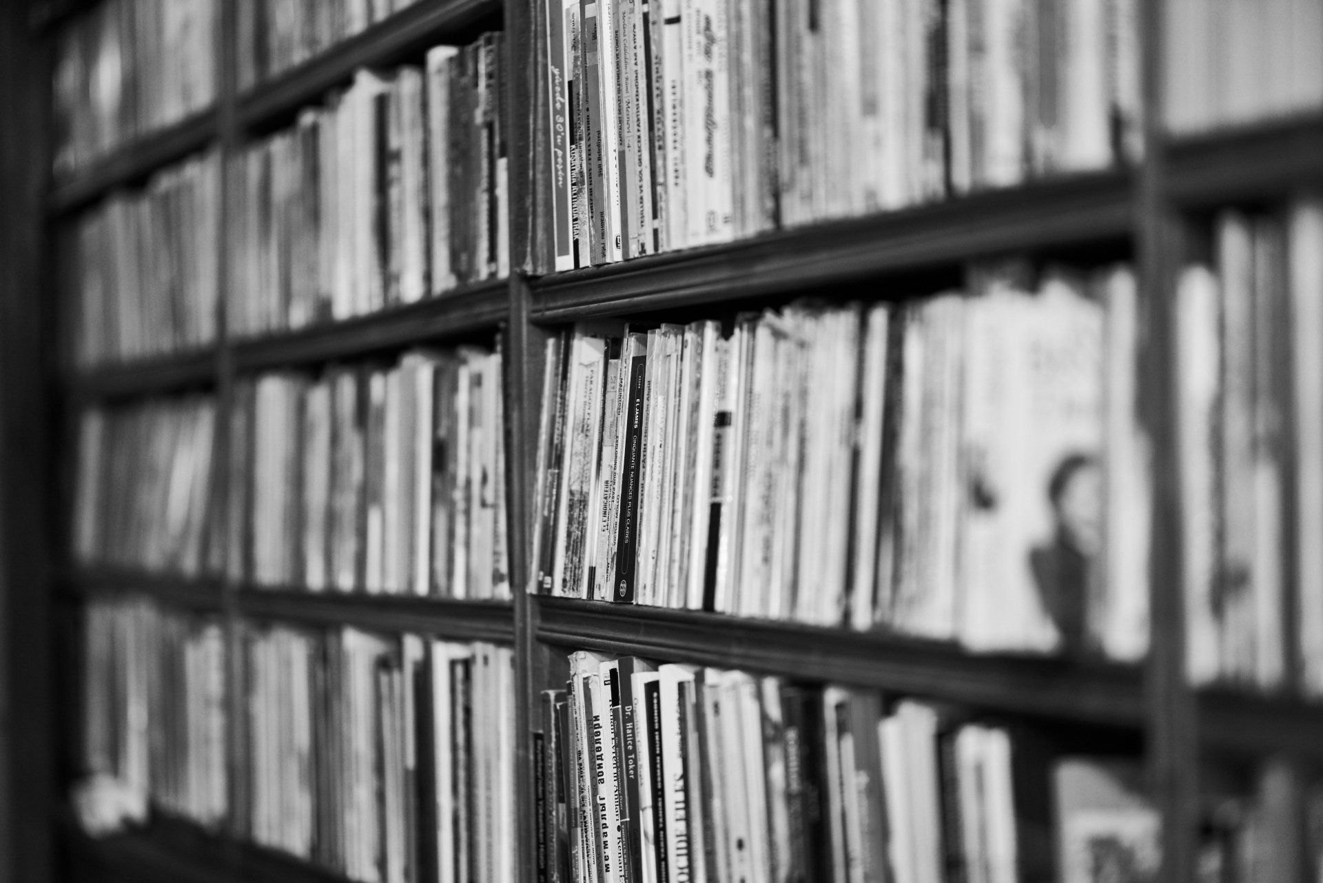 a black and white photo of a bookshelf filled with books representing tax and accounting resources