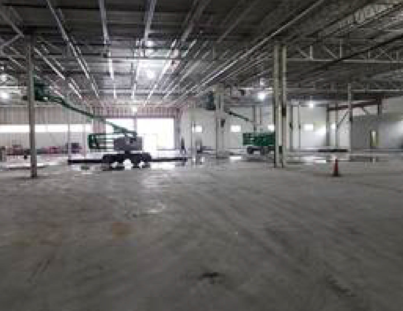 A large empty warehouse with a lot of machinery in it.