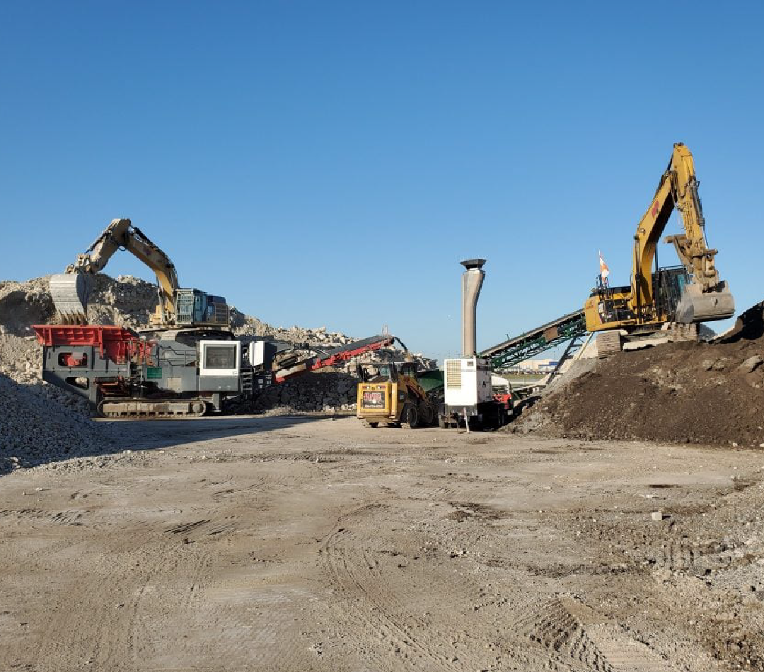 A large pile of dirt is in the middle of a construction site