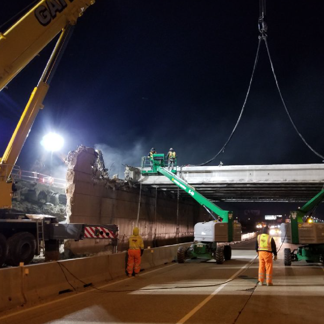 Construction workers are working on a bridge at night