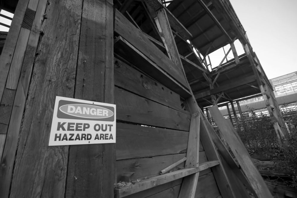 A black-and-white low-angle shot of a dilapidated wooden structure with a 
